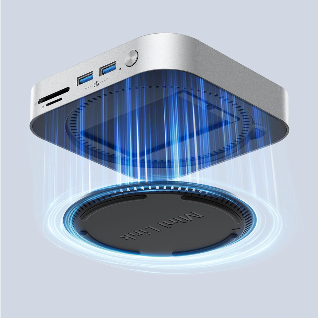 Srebrny mini PC z otworami wentylacyjnymi, niebieskie promienie światła emanujące w dół.