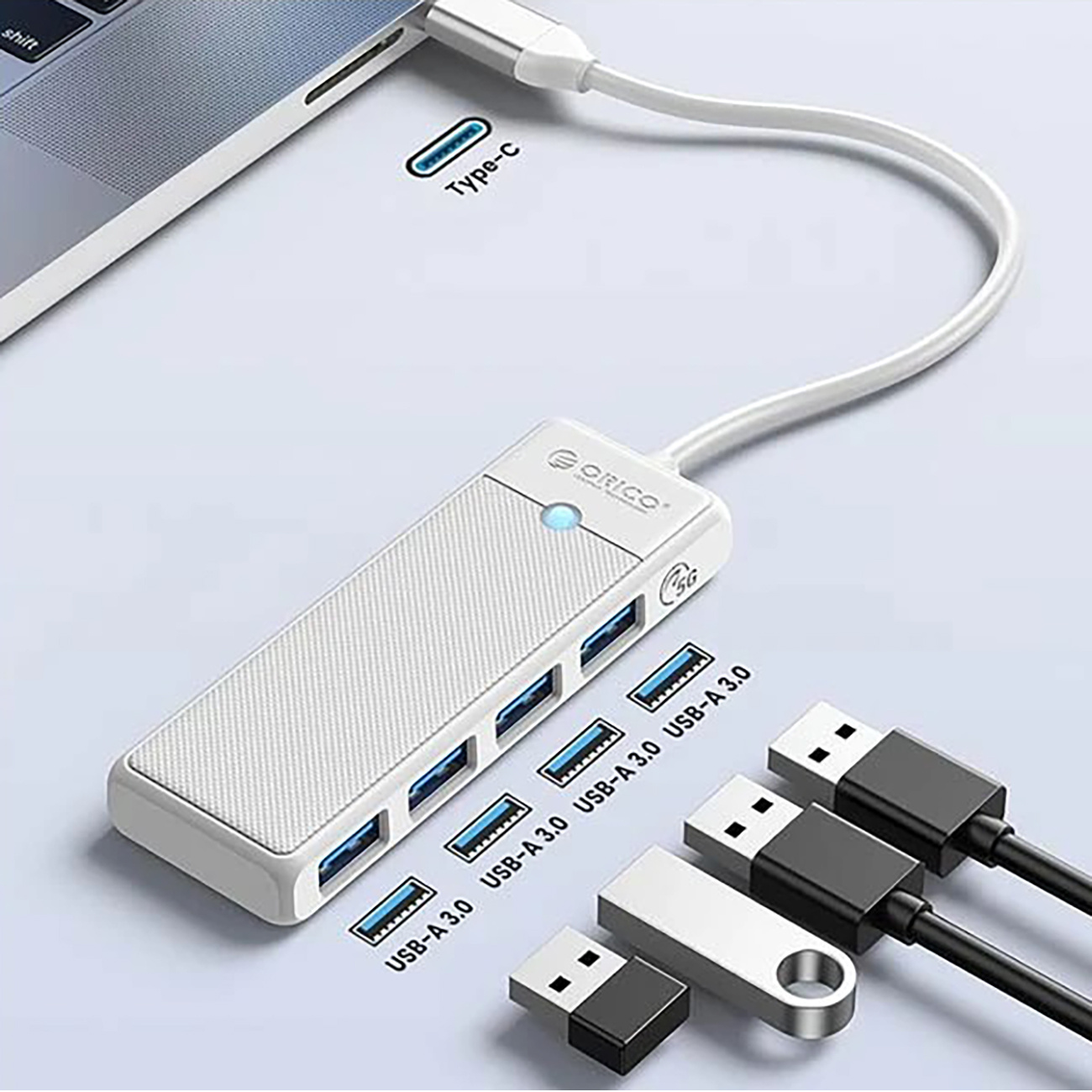 Biały hub USB-C jest podłączony do laptopa, z czterema portami USB-A 3.0 i urządzeniami.