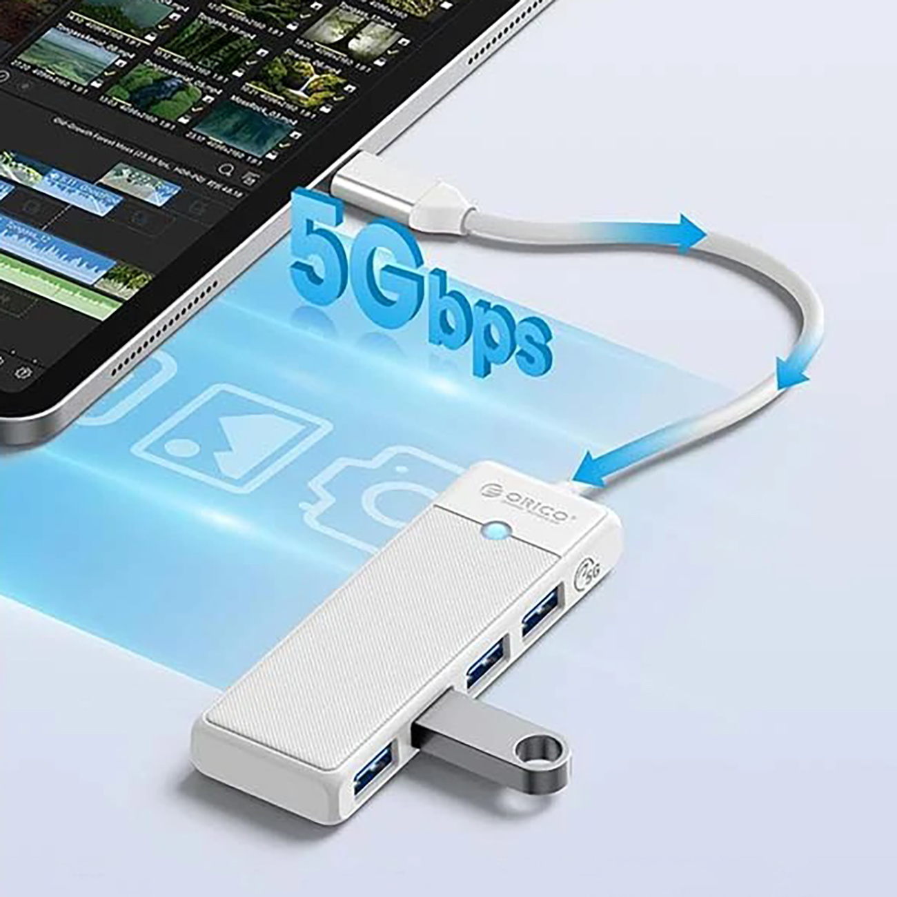 Biały hub USB-C z wieloma portami podłączony do tabletu wyświetlającego 5 Gb/s.
