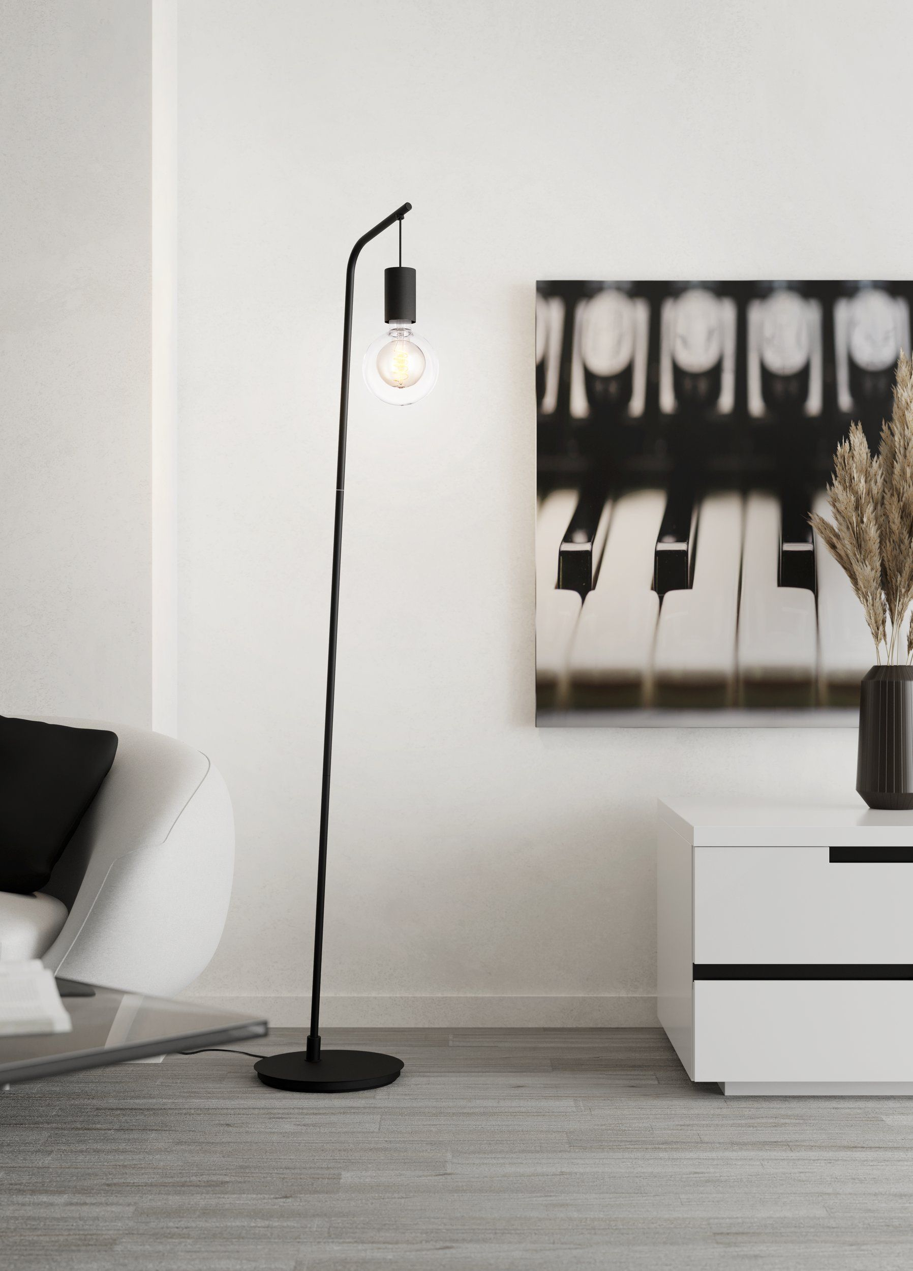 Ein moderner Raum mit einem schwarzen Stehlampen, einem weißen Sofa und einem Klaviertastatur-Bild.
