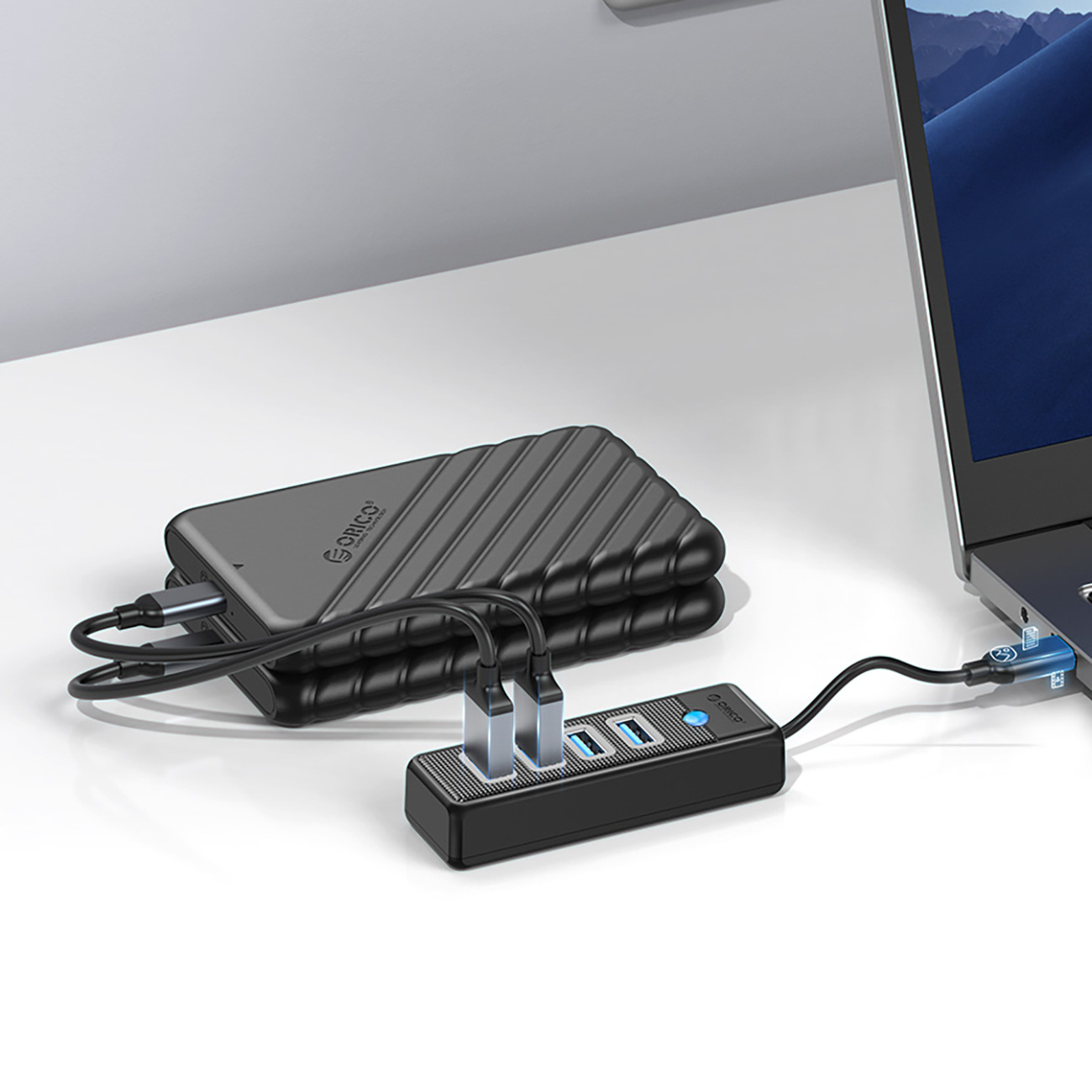 Czarny koncentrator USB z czterema portami jest podłączony do laptopa.