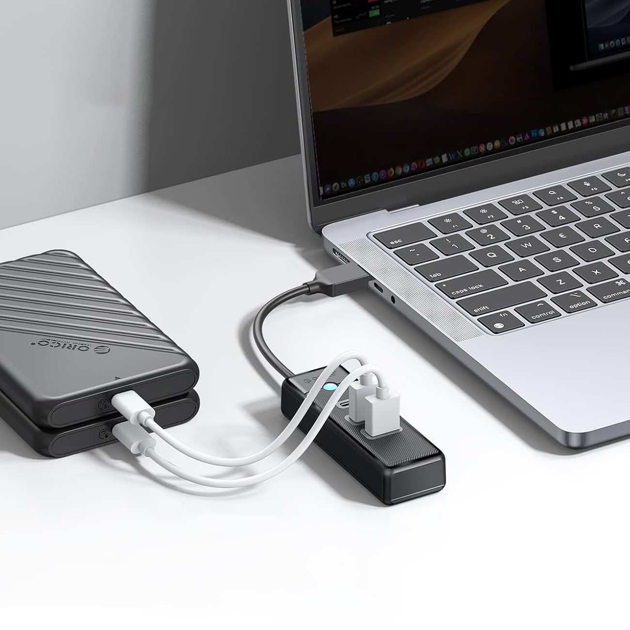 Laptop jest podłączony do huba USB, który jest podłączony do dwóch zewnętrznych dysków twardych.