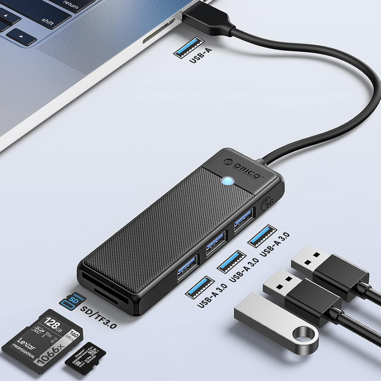 Koncentrator USB ze slotami na karty SD/TF podłączony do laptopa. Zawiera karty pamięci i pendrive'y.
