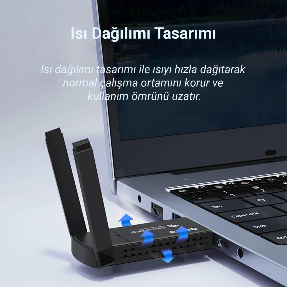 Antenli siyah USB adaptör dizüstü bilgisayara takılı. Mavi oklar ısı dağılımını gösteriyor.