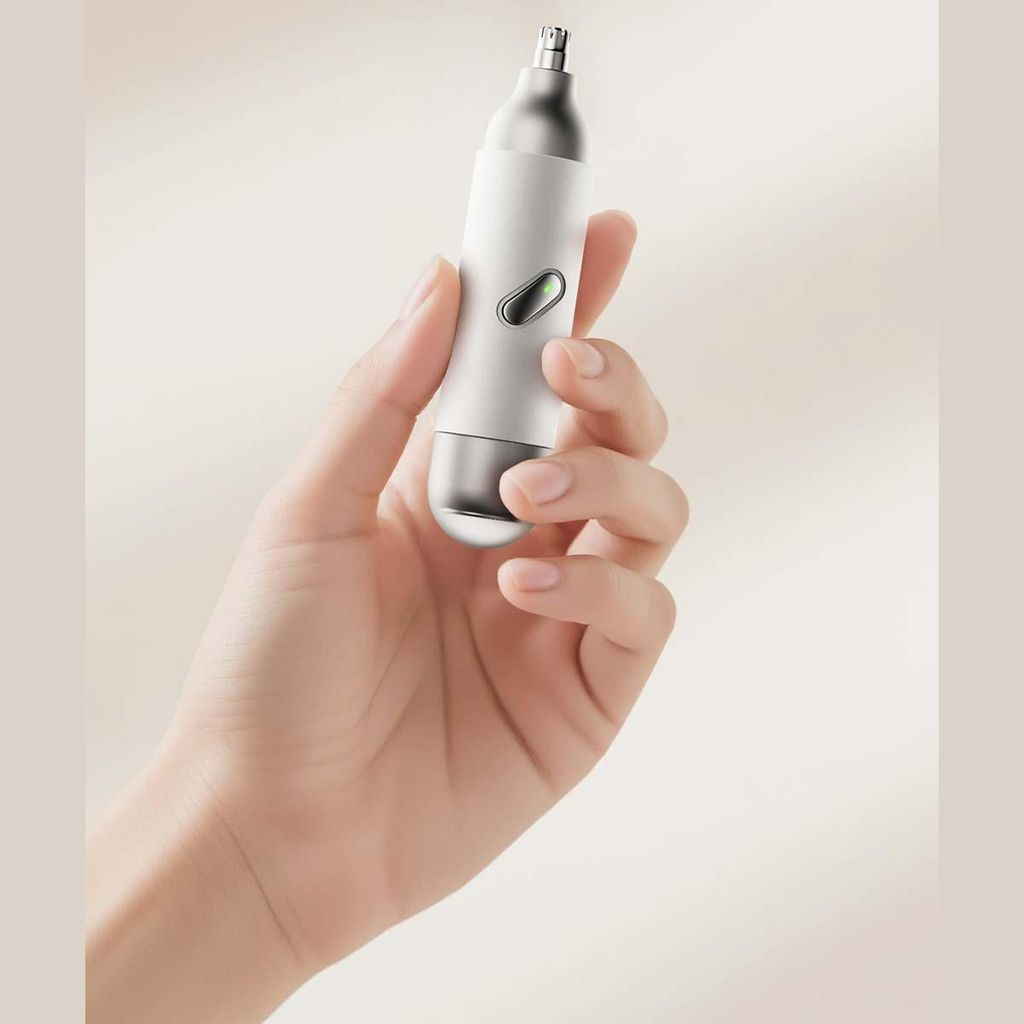 Eine Hand hält einen weißen und silbernen Nasenhaartrimmer mit grünem Licht.