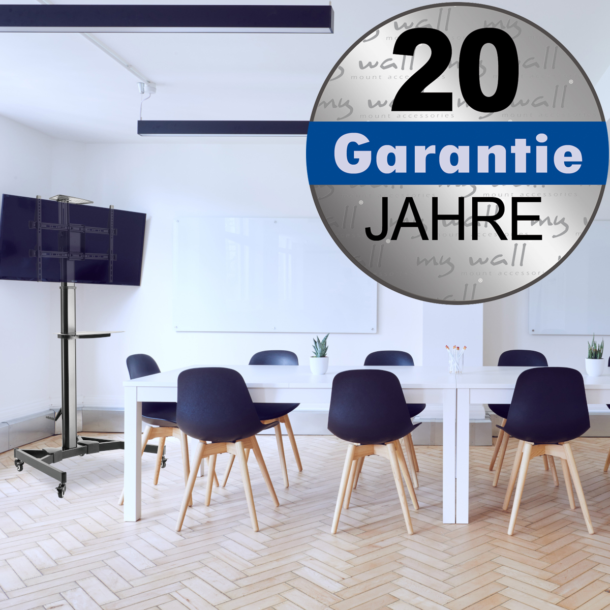 Ein mobiler TV-Ständer steht in einem Konferenzraum mit einem Tisch und Stühlen.