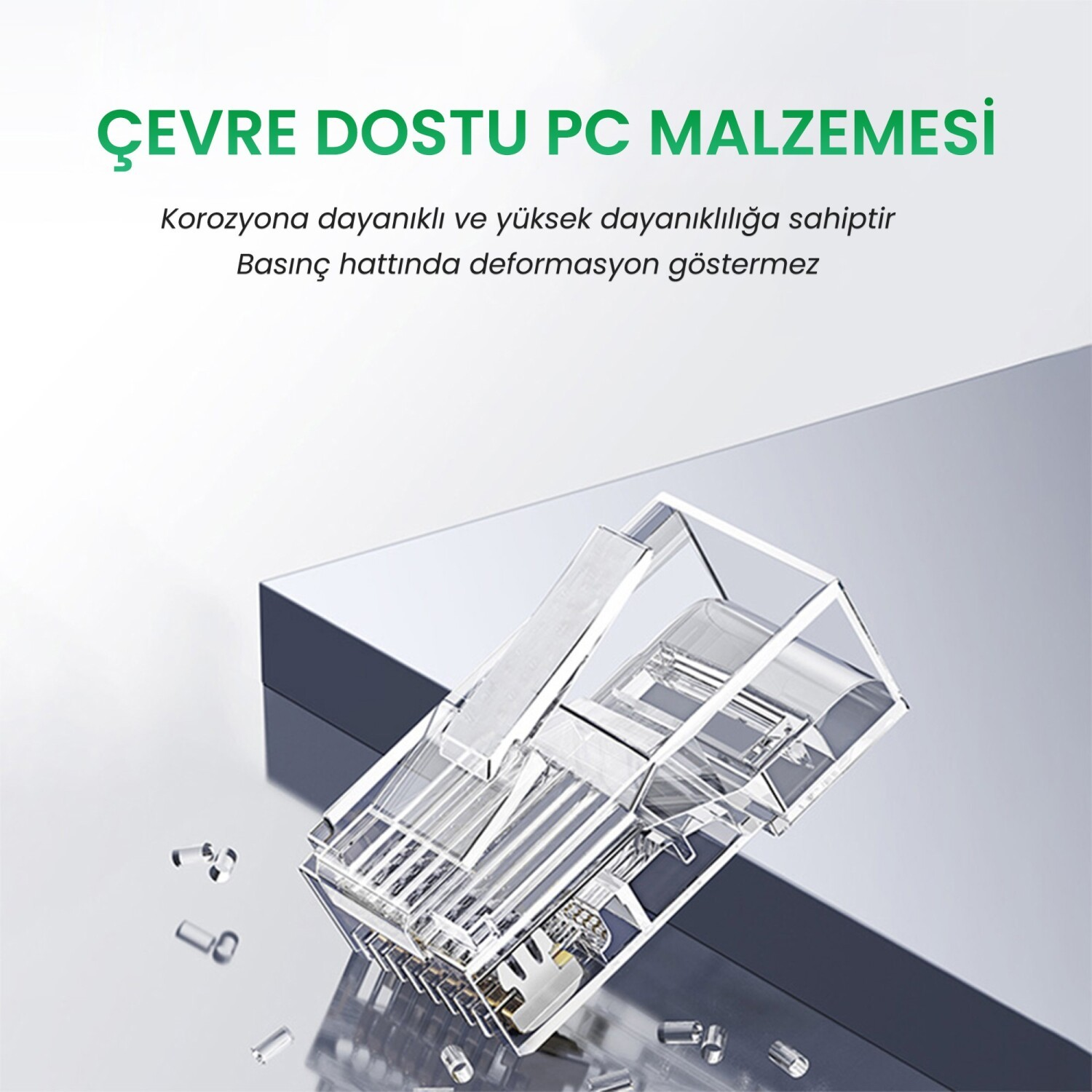 Şeffaf RJ45 konektör, yakında küçük parçalarla gri bir yüzeyde duruyor.