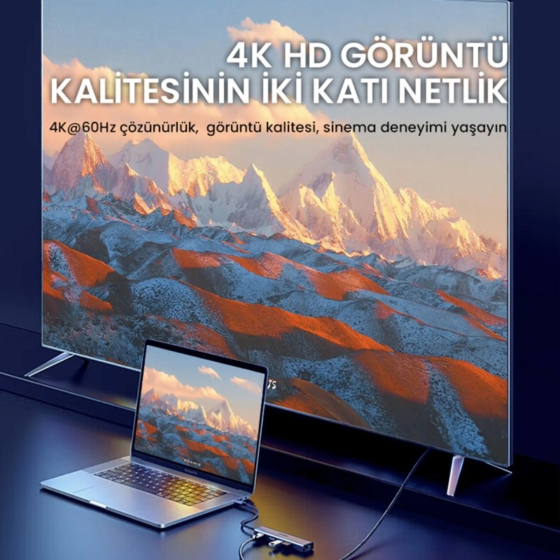 Bir laptop, dağ manzarasını gösteren büyük bir 4K TV'ye bağlanıyor.