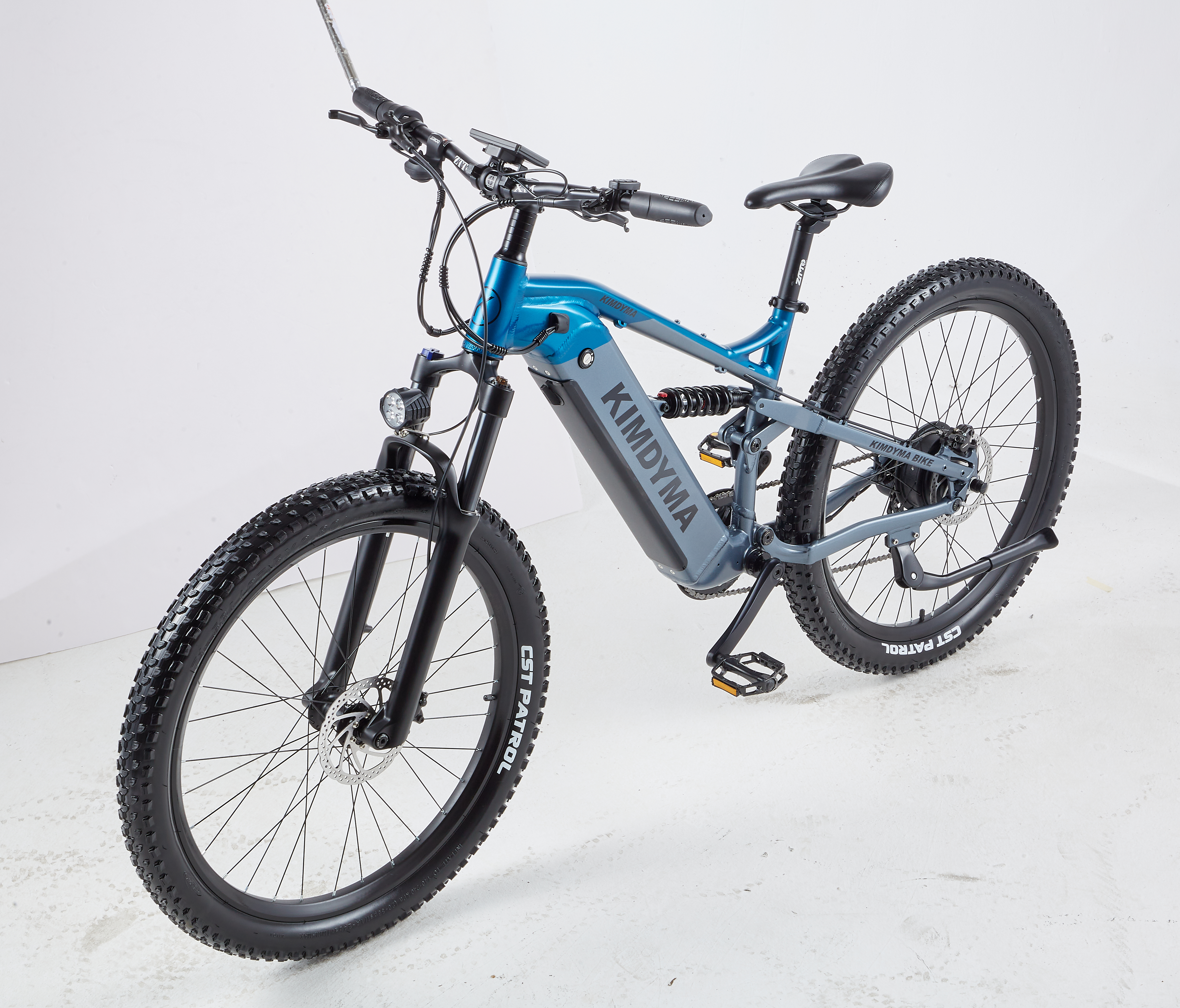 Ein blaues und graues E-Bike mit fetten Reifen und Federung steht auf weißem Hintergrund.