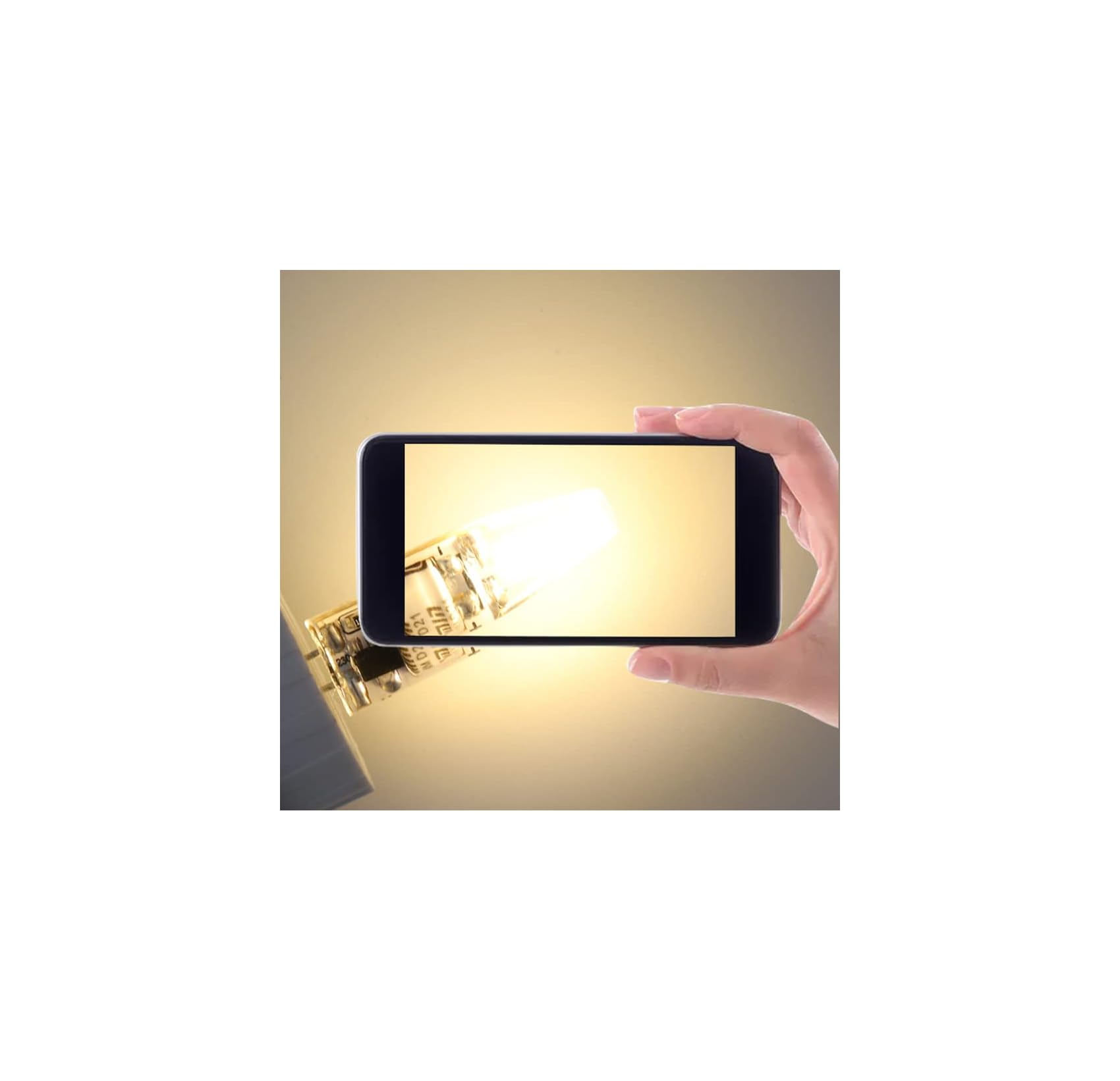 Eine Hand hält ein Smartphone, das eine leuchtende Glühbirne zeigt.