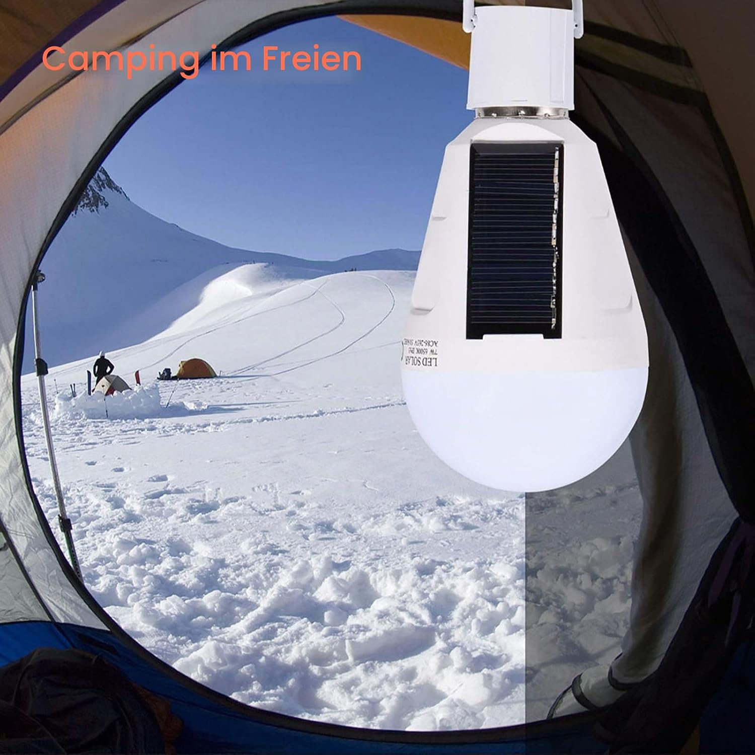 Eine Solar-LED-Lampe hängt vor einem Zelt mit verschneiten Bergen im Hintergrund.