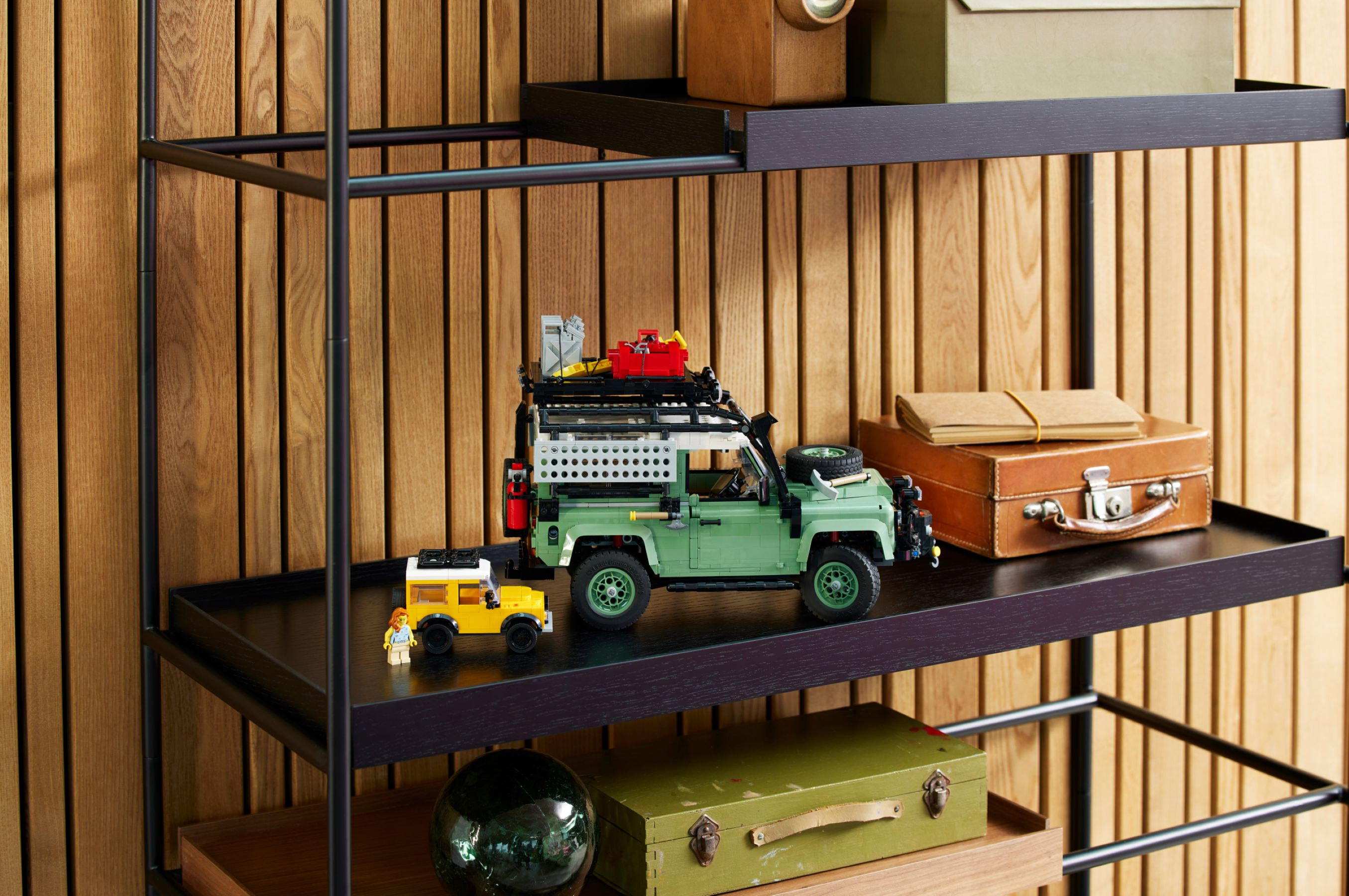 Veicolo Lego verde con portapacchi e un mini veicolo giallo accanto.