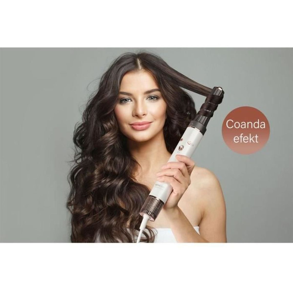 Una donna con lunghi capelli scuri usa un arricciacapelli bianco per acconciare una ciocca.