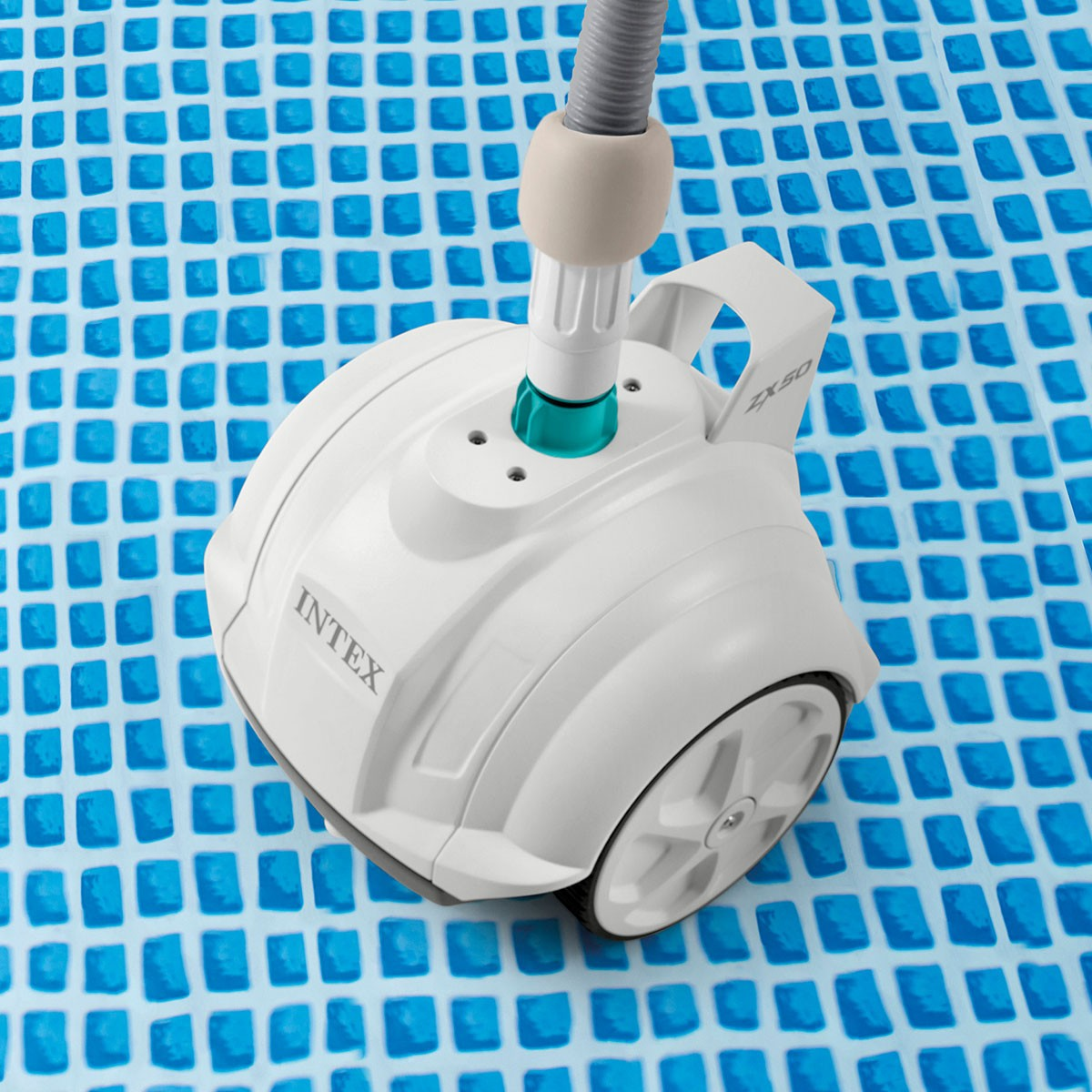 Un pulitore per piscina bianco con ruote su una superficie piastrellata blu.