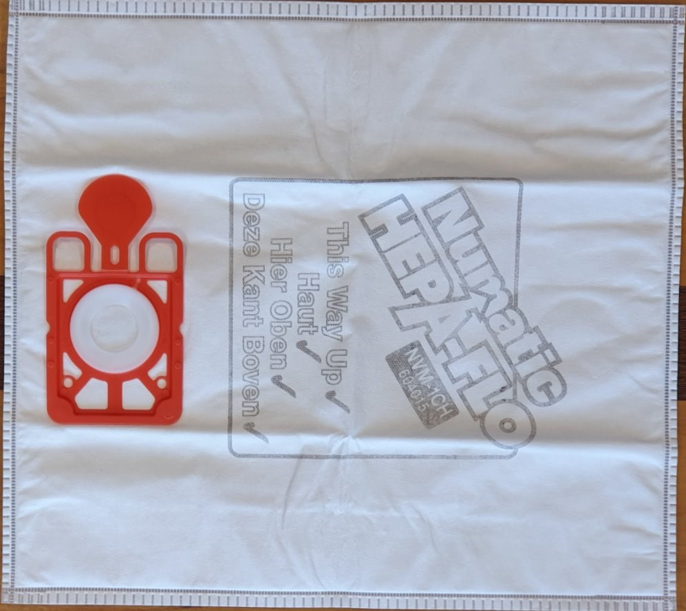 Una bolsa de aspiradora blanca con adaptador de plástico rojo y estampado.