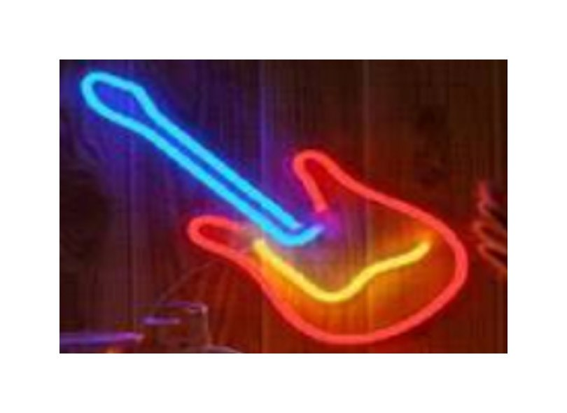 A neon guitar glows in blue, red, and yellow against a wooden wall.