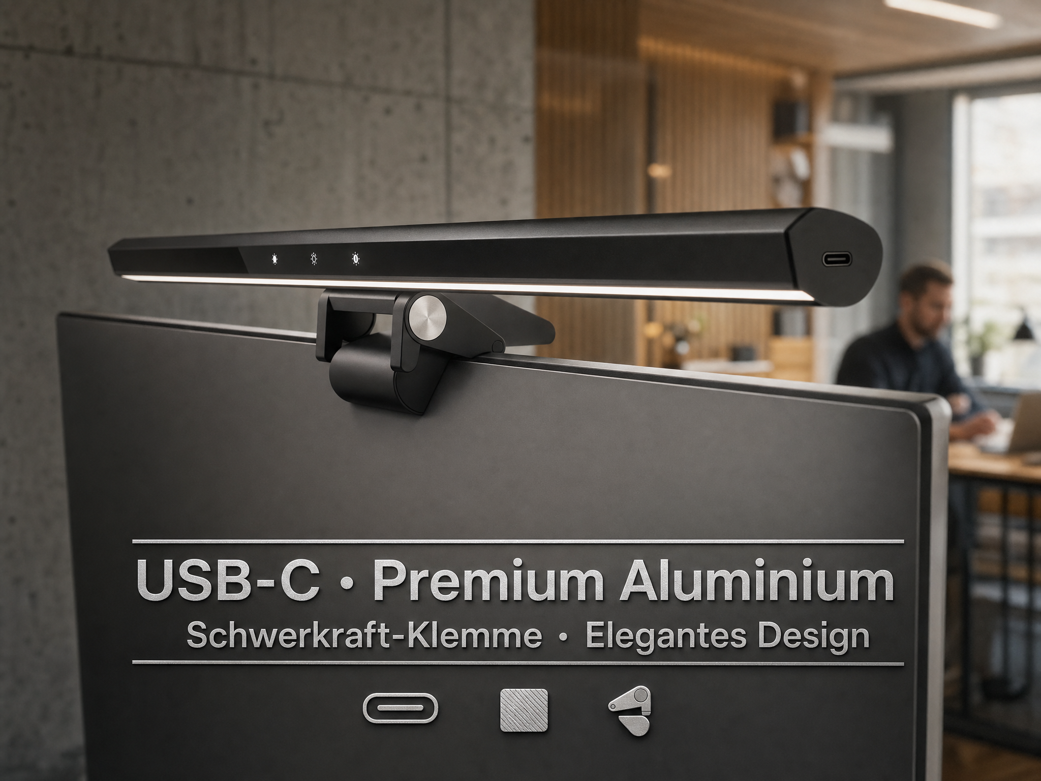 Schwarze Monitorlampe mit USB-C-Anschluss, montiert auf einem Monitor. Mann im Hintergrund.