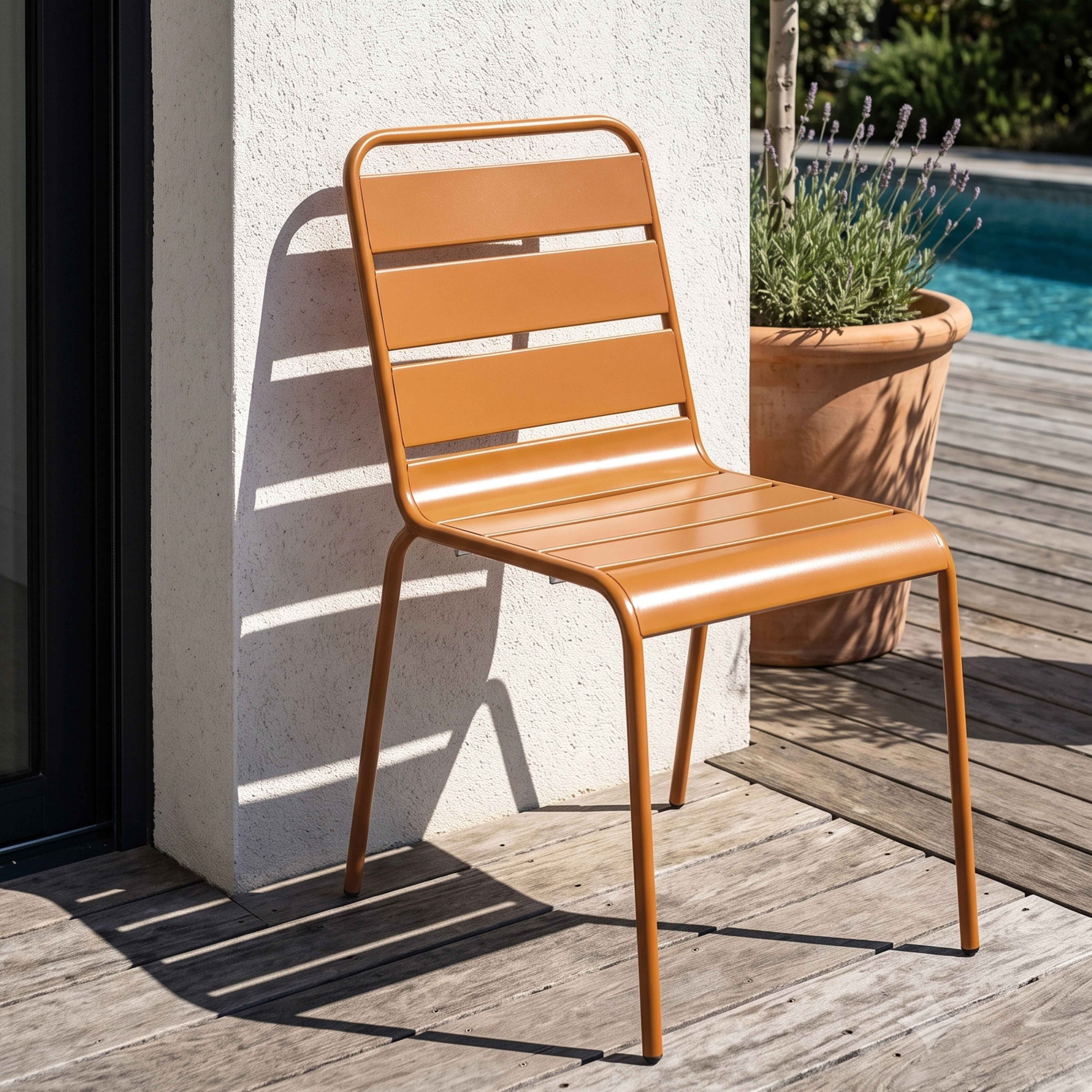 Ein orangefarner Gartenstuhl steht auf einer Holzterrasse neben einem Pool.