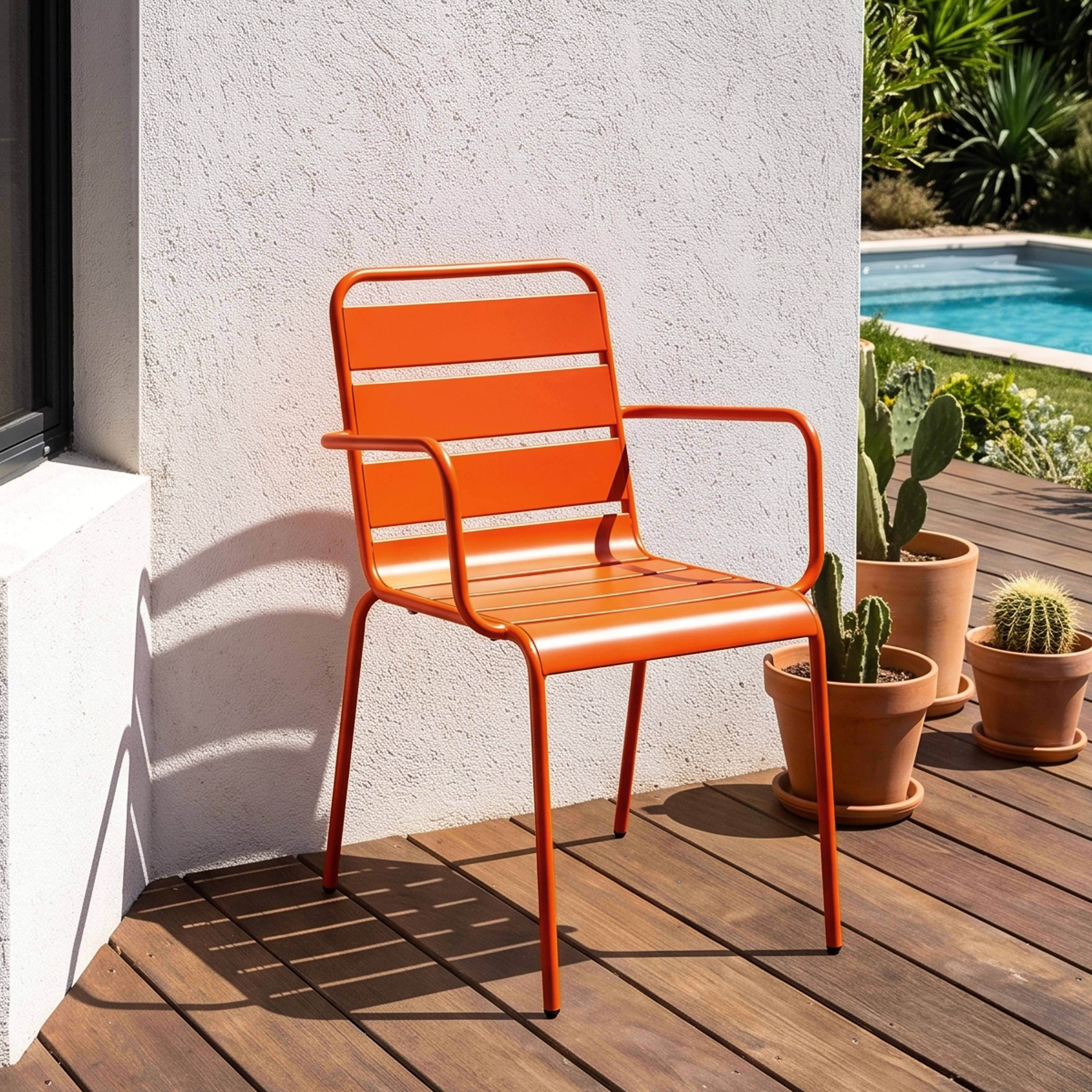 Ein orangefarner Stuhl steht auf einer Holzterrasse neben Kakteen und einem Pool.