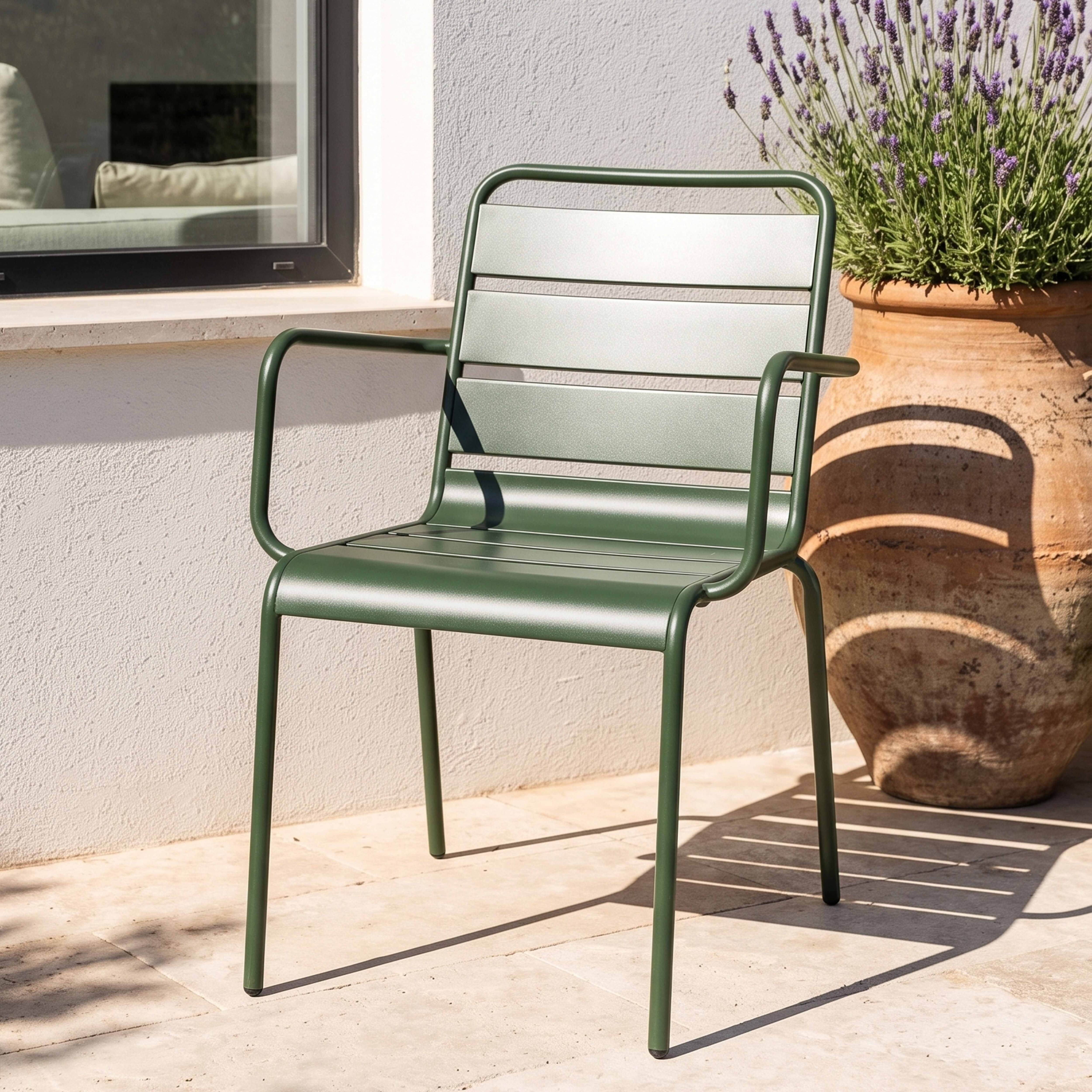 Grüner Metallstuhl steht neben einem großen Terrakotta-Topf mit Lavendel.