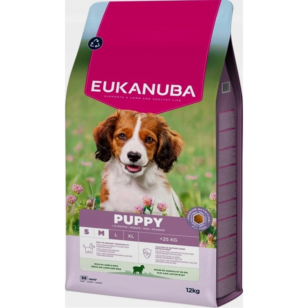 Torba karmy dla szczeniąt Eukanuba z uroczym szczeniakiem na kwiecistej łące.