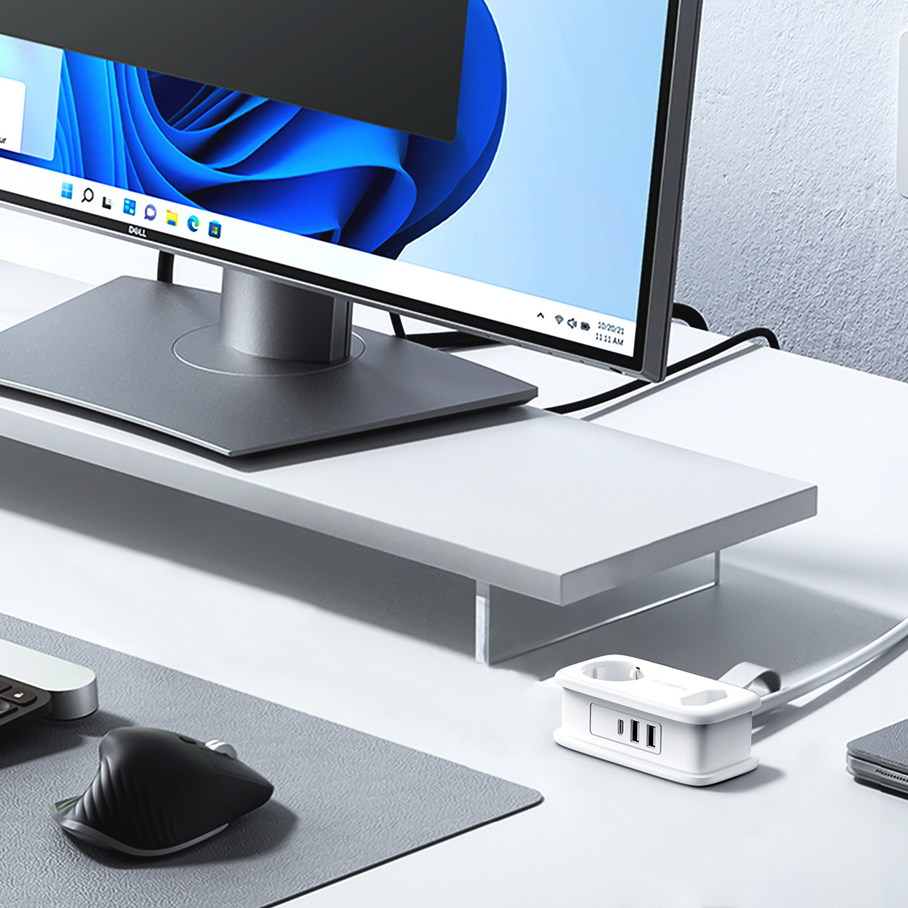 Biała listwa zasilająca z portami USB na biurku obok monitora i myszy.