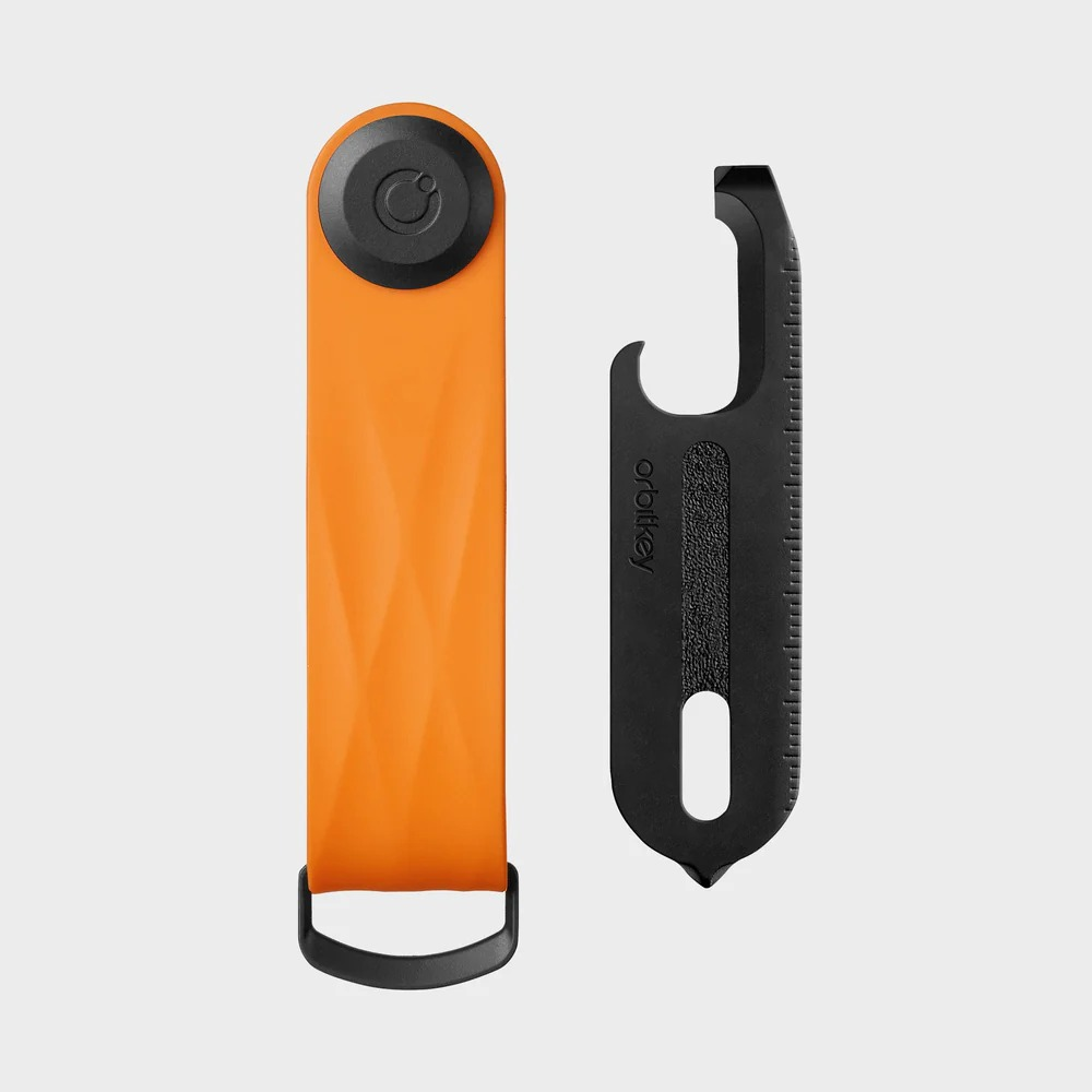 Pomarańczowy Orbitkey i czarne wielofunkcyjne narzędzie leżą obok siebie.