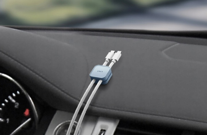 Niebieski kabel ładujący z dwoma złączami USB-C na ciemnej desce rozdzielczej samochodu.