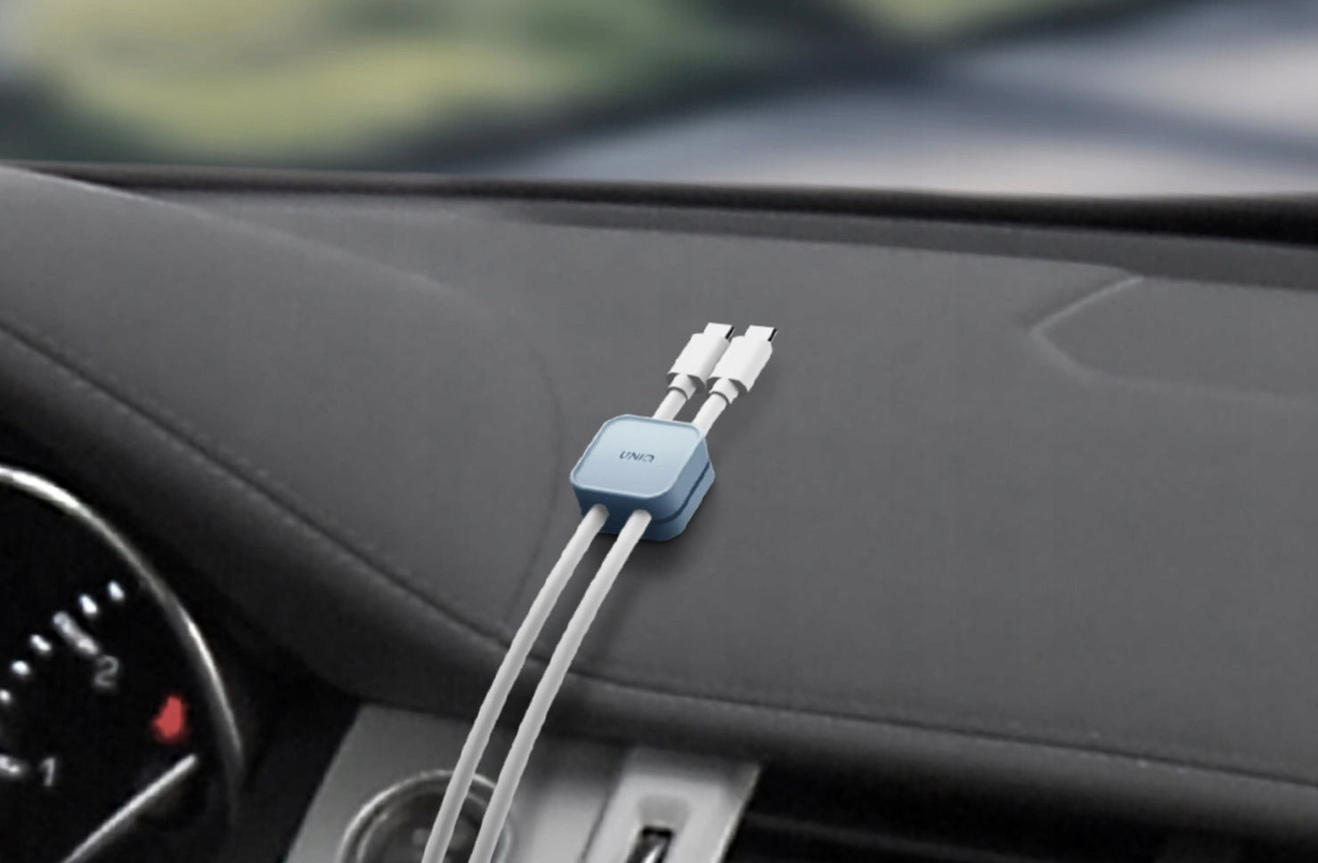 Niebieski rozdzielacz kabli ładowania z dwoma białymi kablami USB-C na desce rozdzielczej.