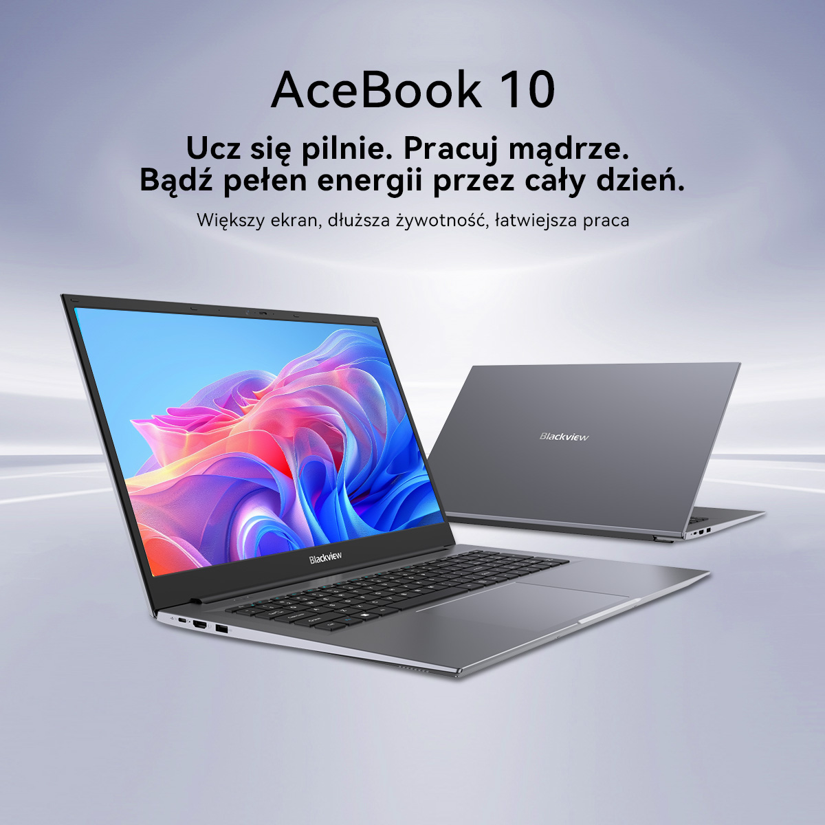 Dwa szare laptopy, jeden otwarty z kolorową tapetą, drugi zamknięty.