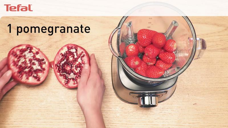 Połówka granatu i truskawki w blenderze.