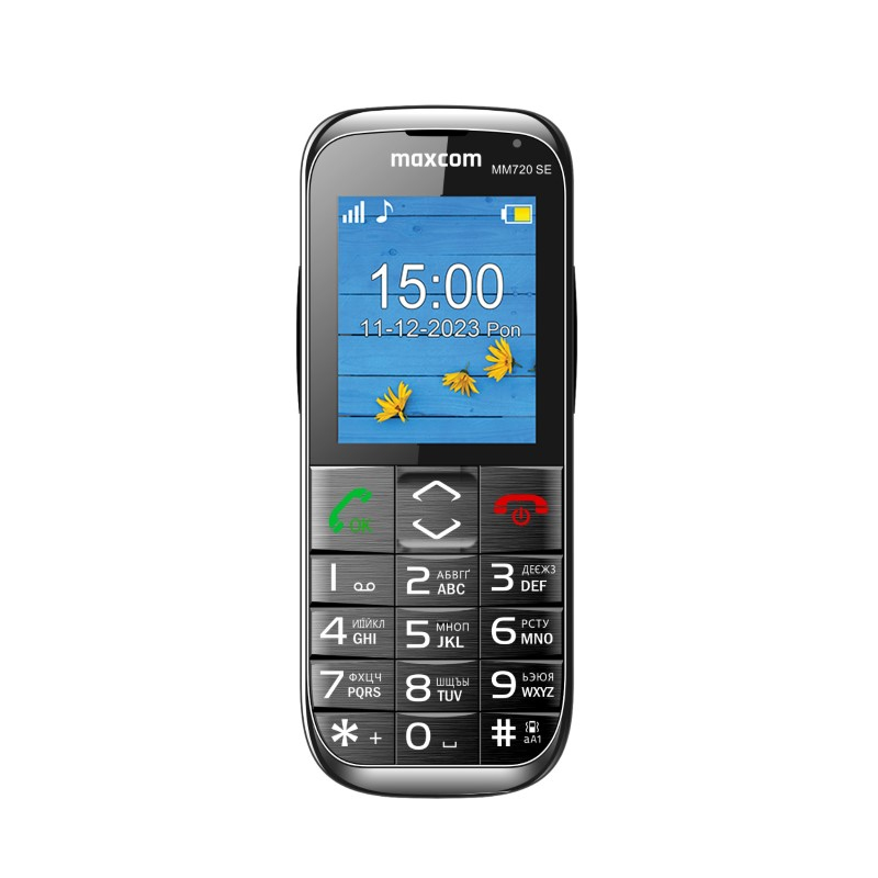 Telefono Maxcom MM720 SE mostra le 15:00 su sfondo legno blu con fiori gialli.