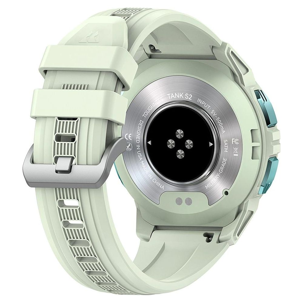 Tył jasnooliwkowej smartwatch z metalową klamrą i stykami ładowania.