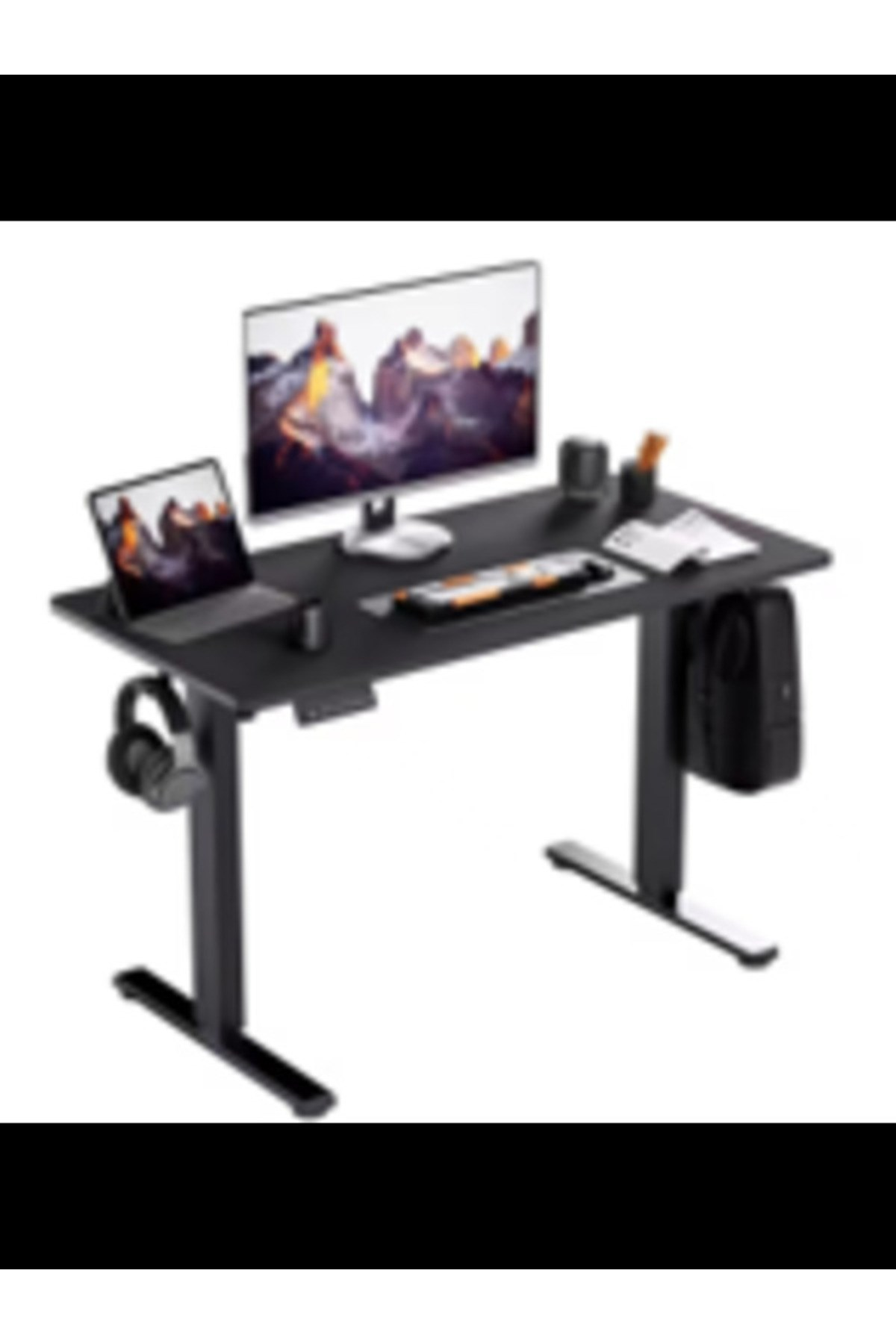 Laptop, monitör, klavye ve kulaklık içeren siyah ayarlanabilir masa.