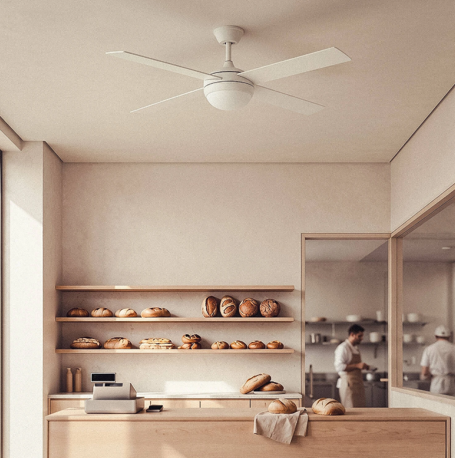 Bäckereitheke mit Regalen voller Brot, Kasse und Deckenventilator.