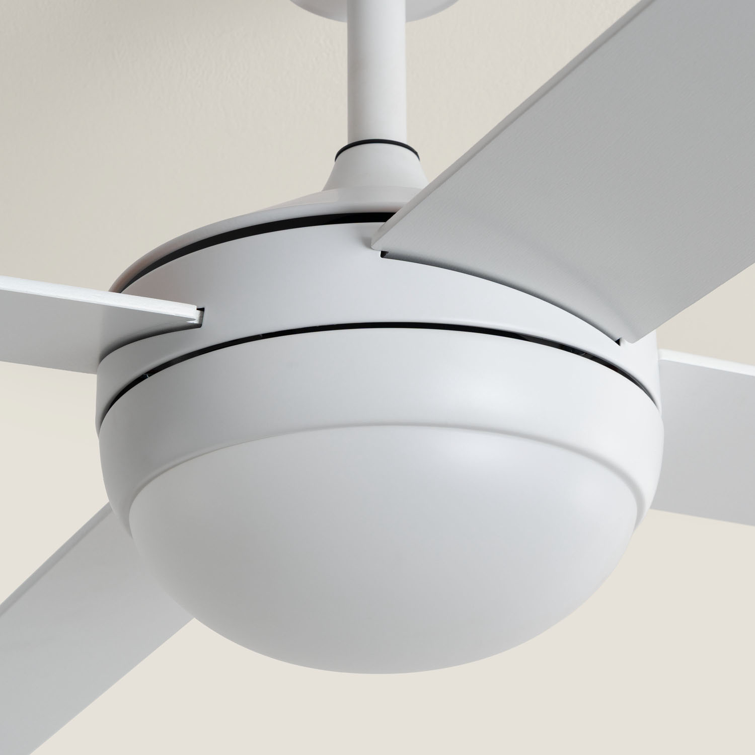 Ein moderner weißer Deckenventilator mit drei schlanken Flügeln und einem kugelförmigen Lichtgehäuse.