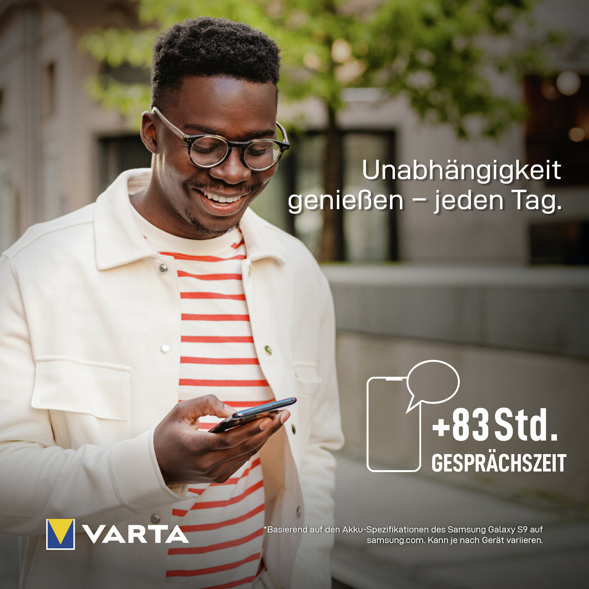 Uomo con occhiali guarda il telefono. Logo Varta. 83 ore di conversazione.