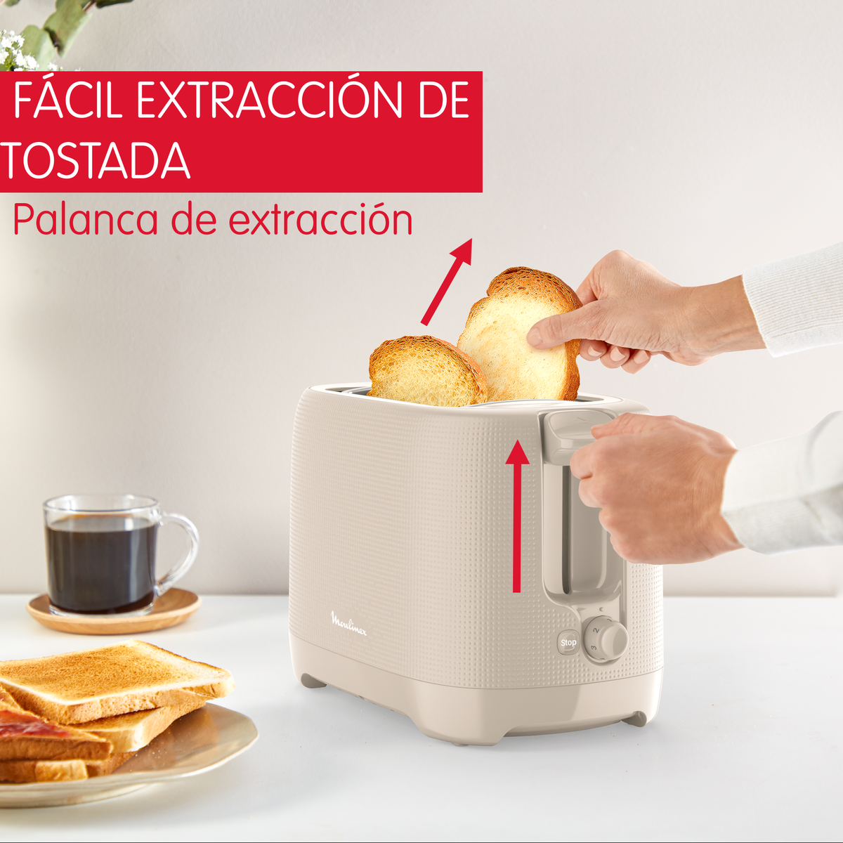 Un tostapane beige con due fette di pane estratte. Caffè e pane tostato sullo sfondo.