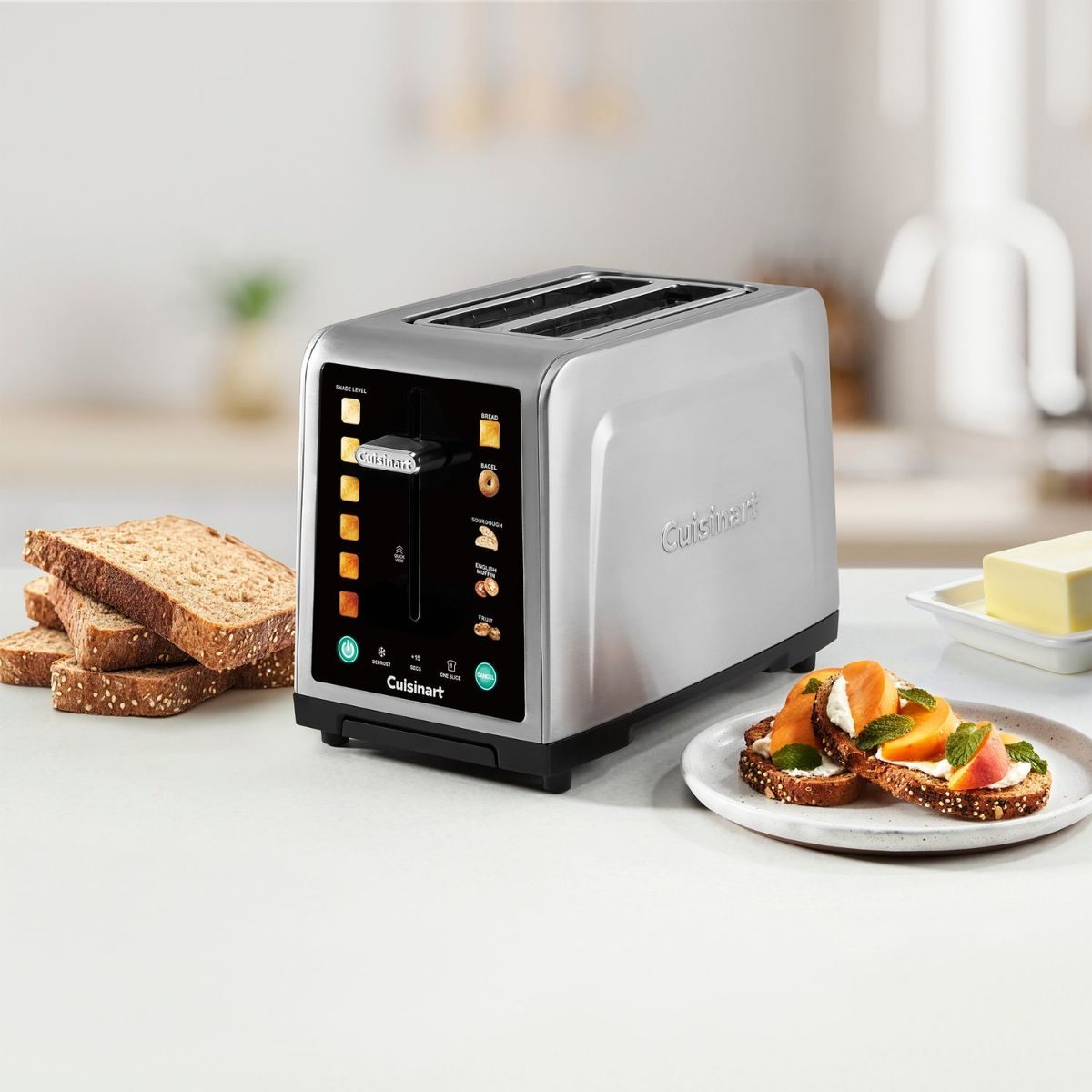 Un tostapane argento con fette di pane, burro e fette di toast guarnite.