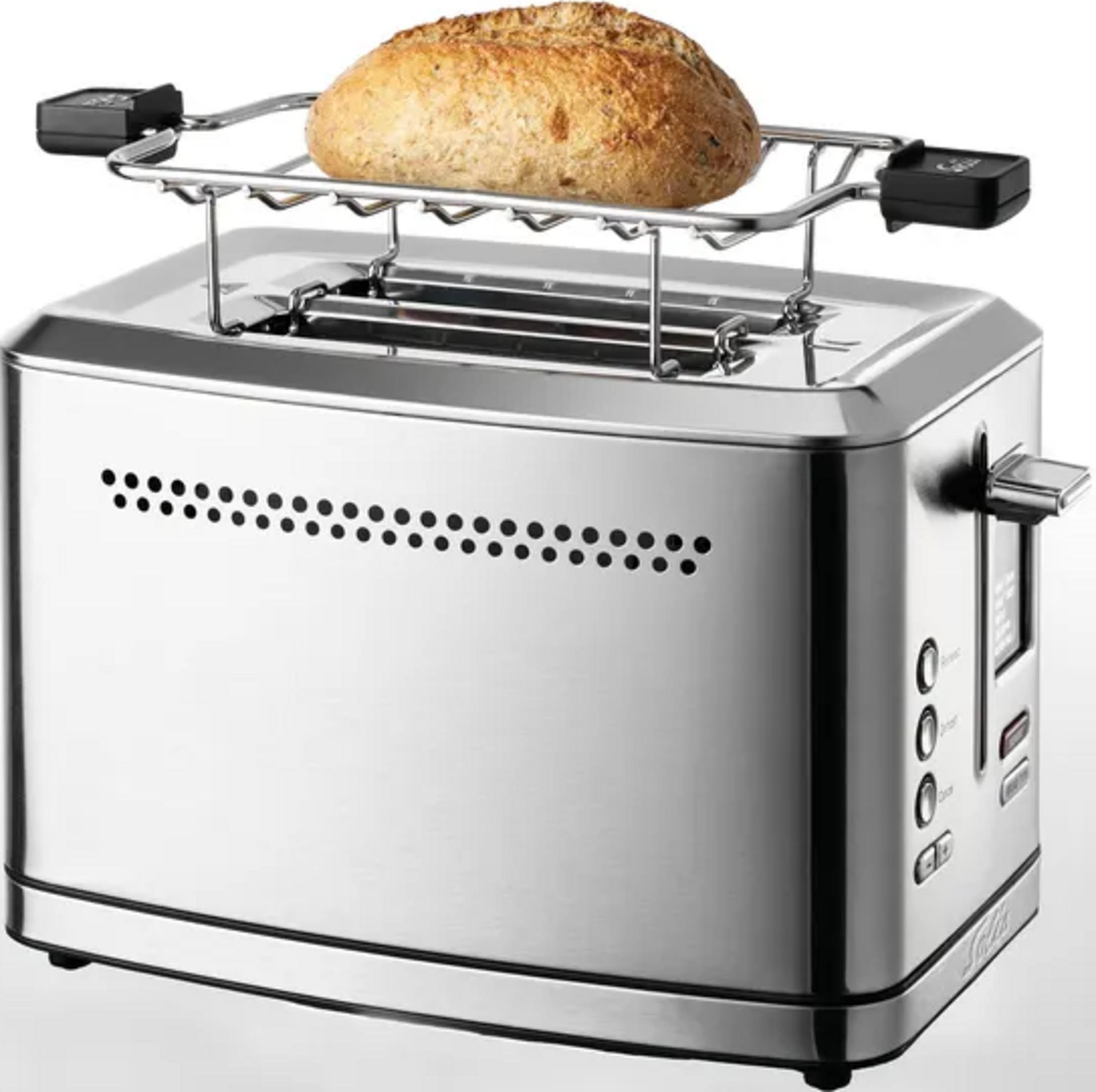 Ein silberner Toaster mit einem auf dem oberen Rost liegenden Brot.
