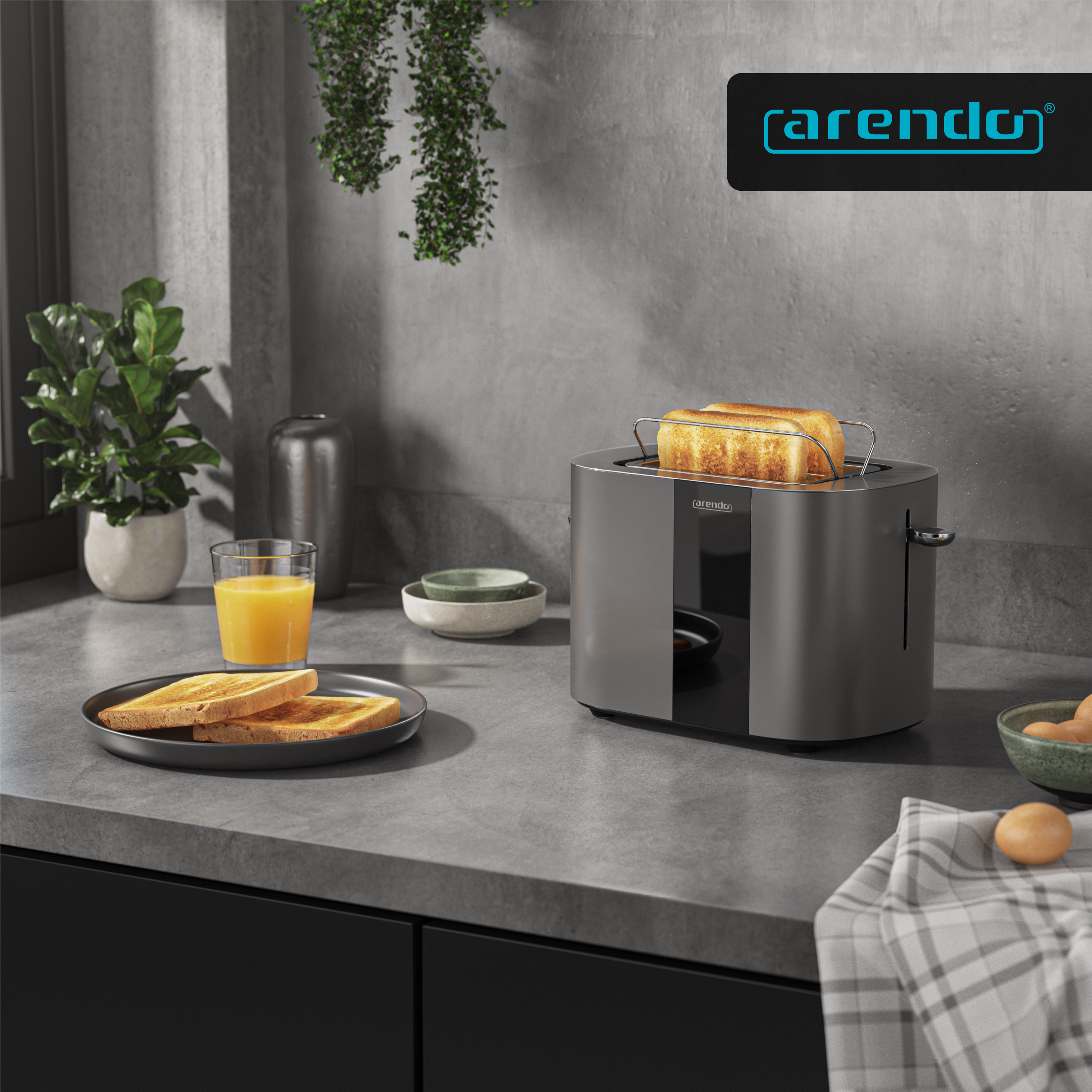 Ein silberner Toaster mit Toast, Saft, Toastbrot und Eiern auf einer Arbeitsplatte.