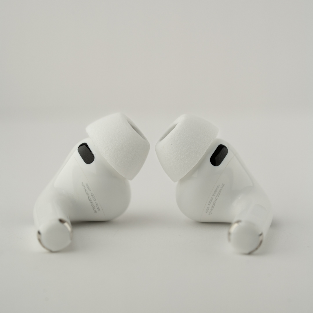 Zwei weiße Apple AirPods Pro Ohrhörer mit weißen Silikonspitzen auf weißem Hintergrund.