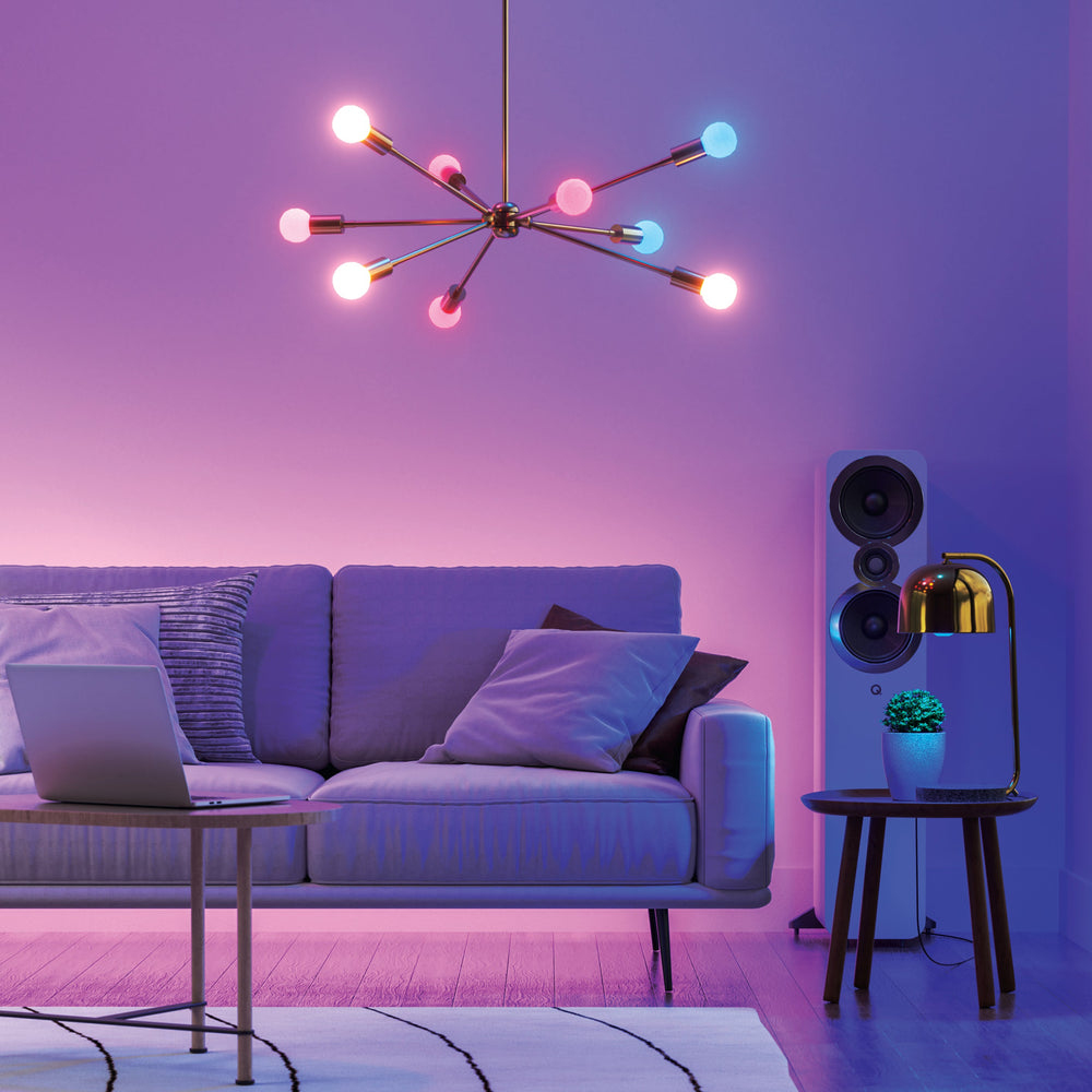 Ein modernes Wohnzimmer mit Sofa, Laptop, Lampe, Lautsprecher und Sternenleuchter.
