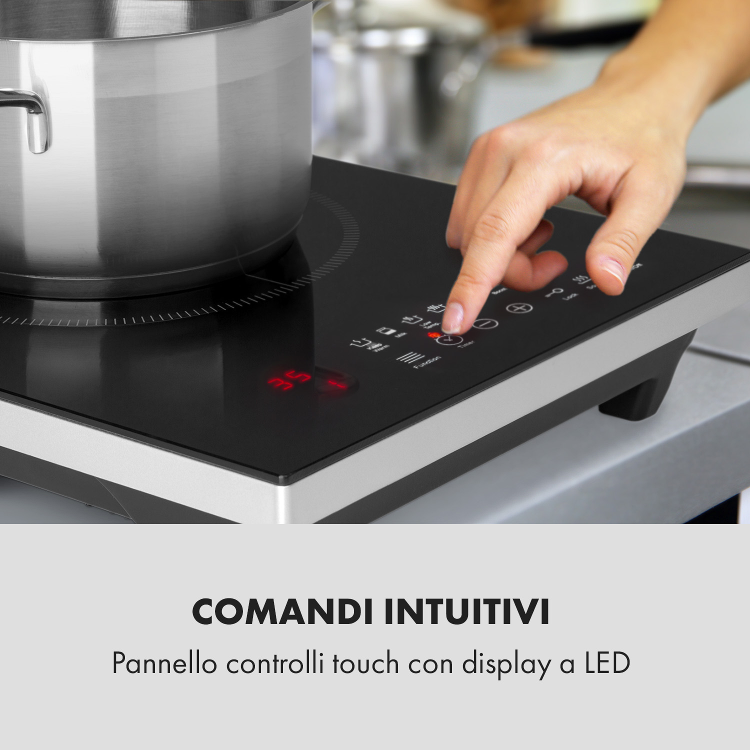 Una mano aziona un piano cottura a induzione con pentola in acciaio inox. Pannello touch.