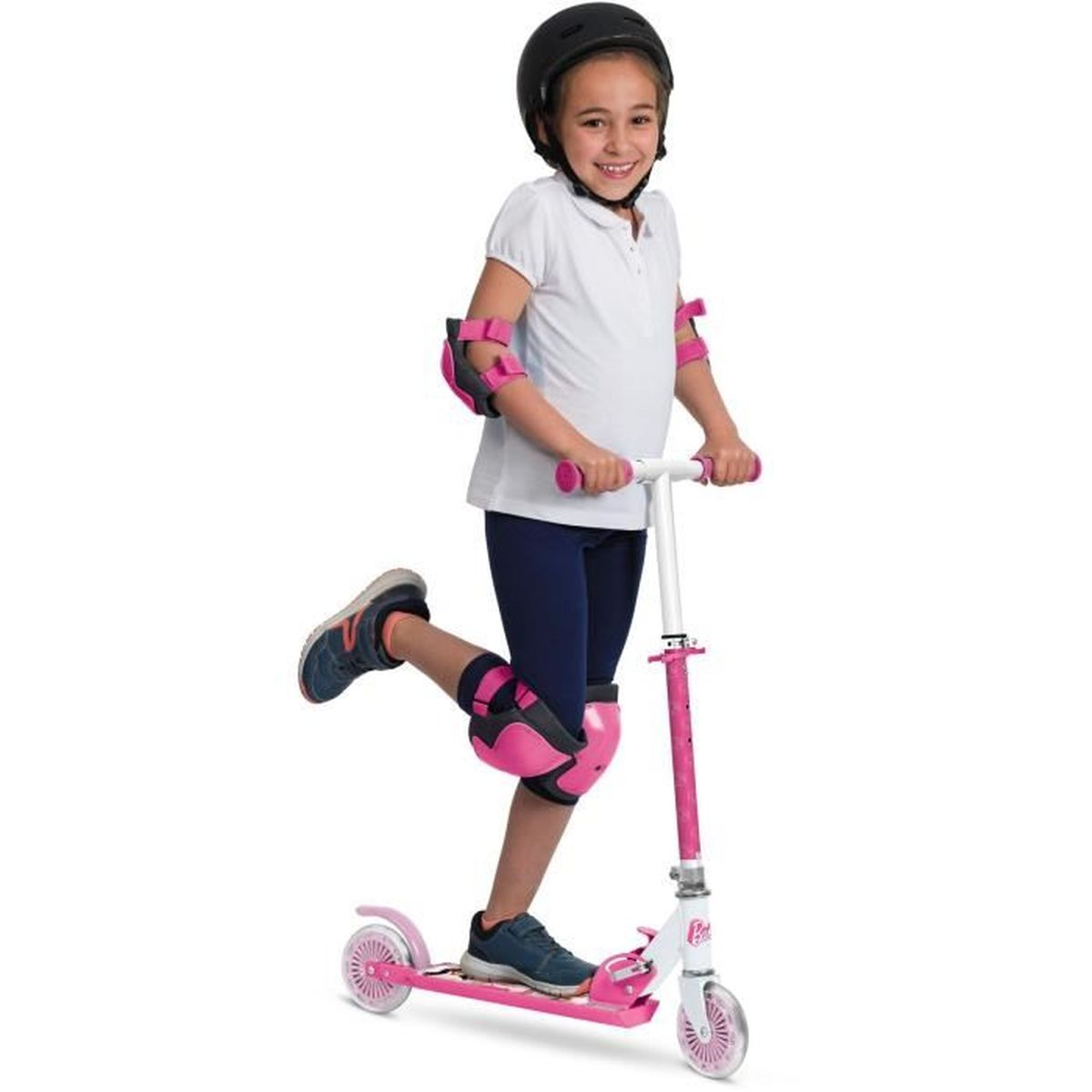 Una bambina con protezioni guida un monopattino rosa su sfondo bianco.