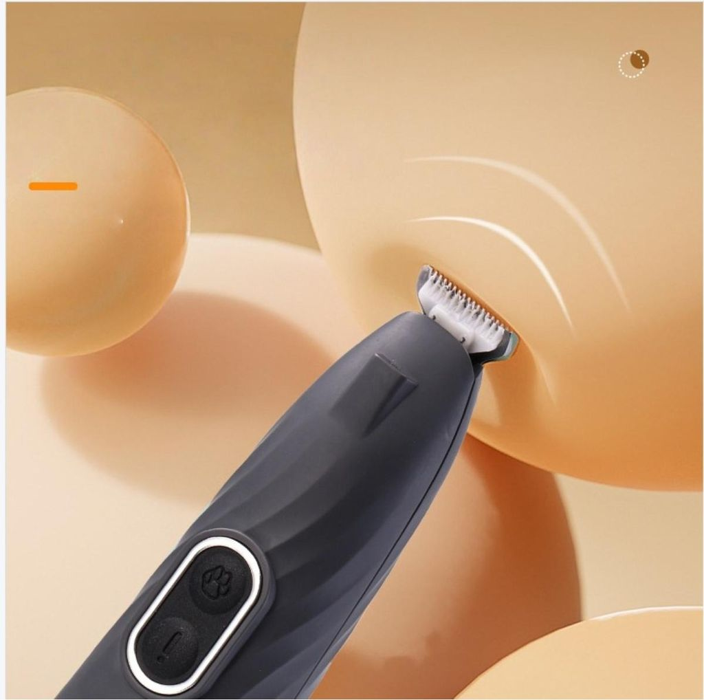 Ein dunkelgrauer Haustierpflege-Trimmer mit Pfotenabdruck-Taste wird nah vor einem weichen, hellbraunen Hintergrund gezeigt.