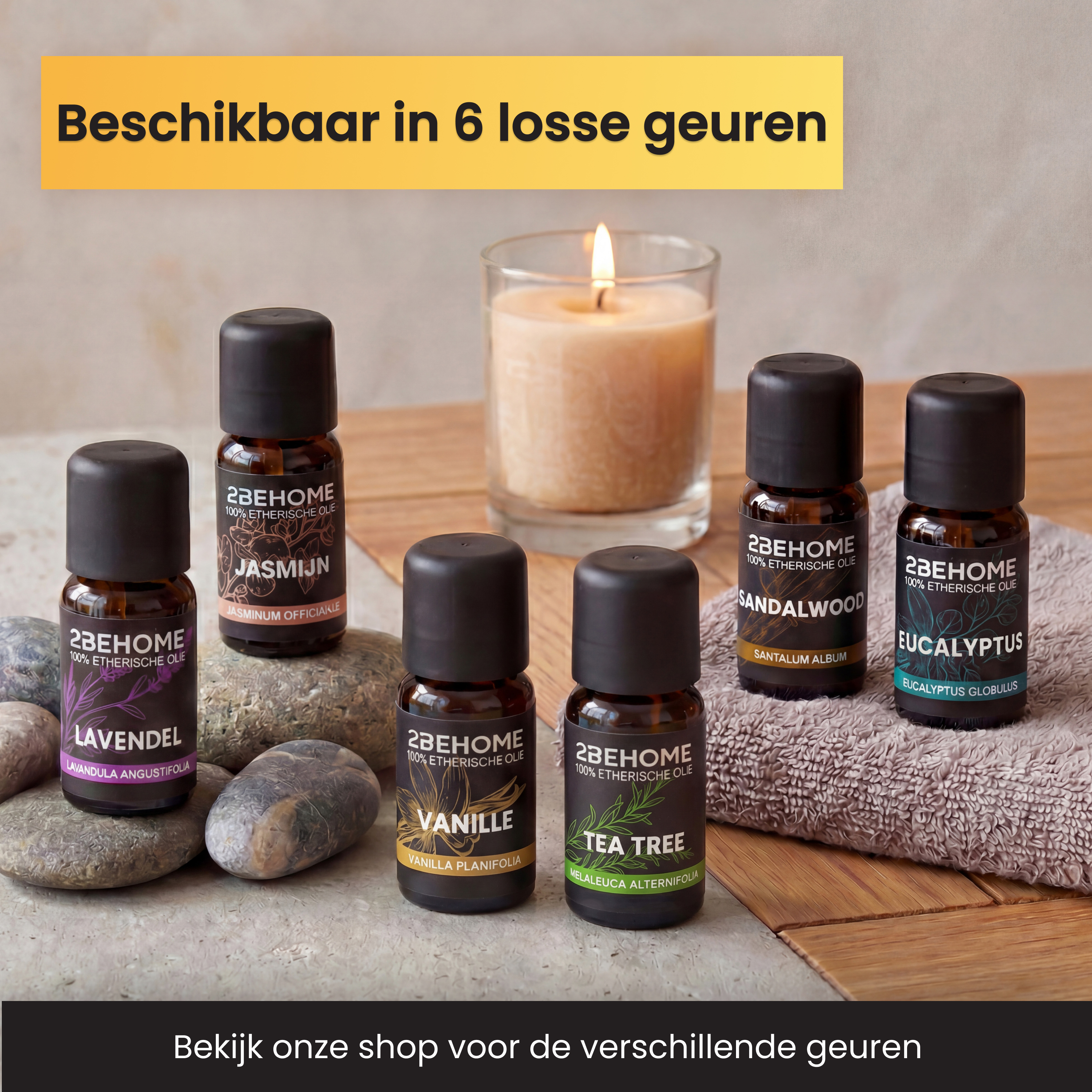 Sechs Fläschchen ätherisches Öl stehen auf Steinen und Handtüchern neben einer Kerze.