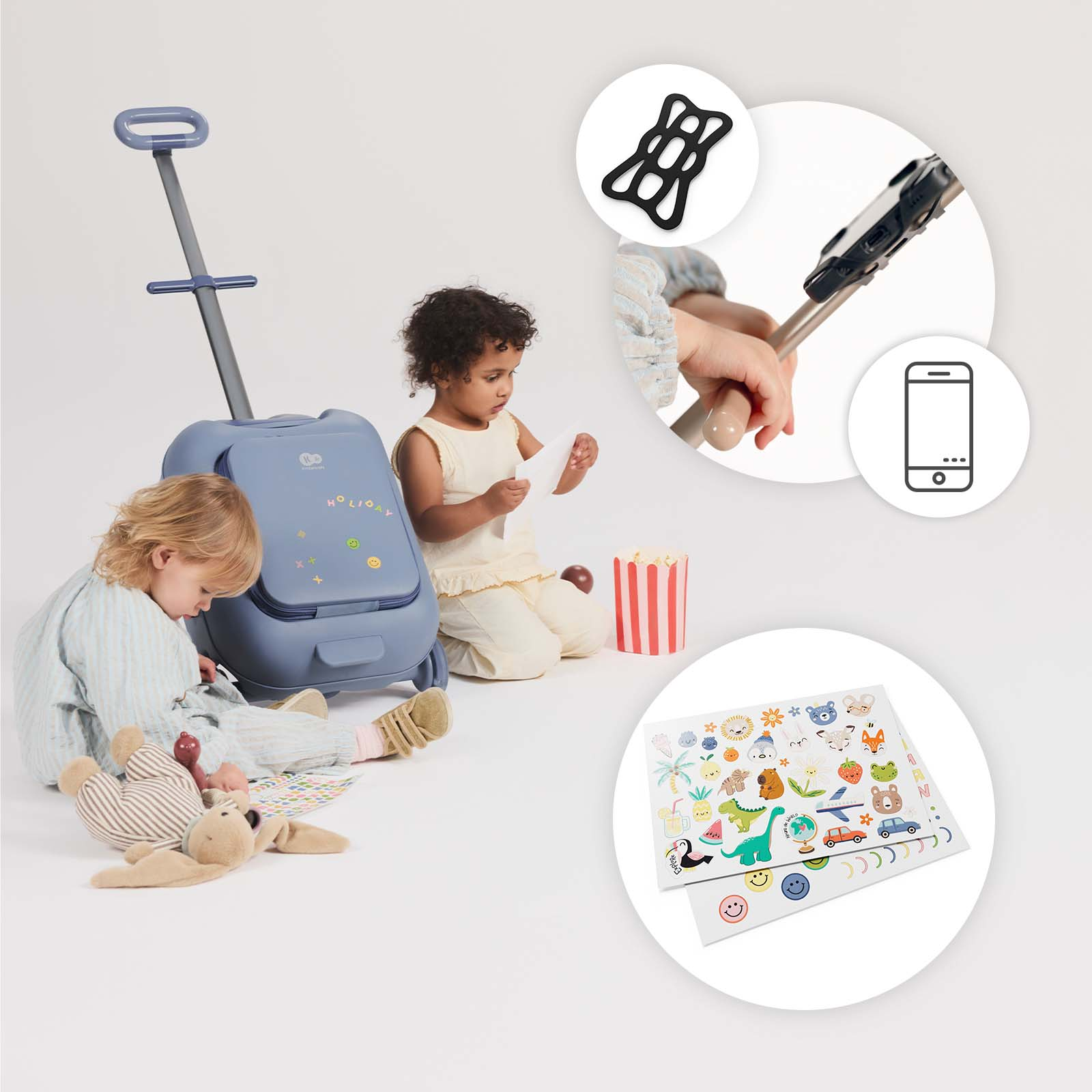 Zwei Kinder spielen mit einem blauen Koffer, Aufklebern und Spielzeug.