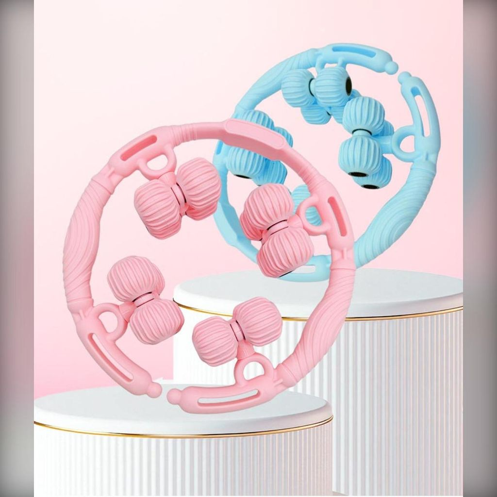 Zwei Massagegeräte, eins rosa, eins blau, auf weißen Podesten.