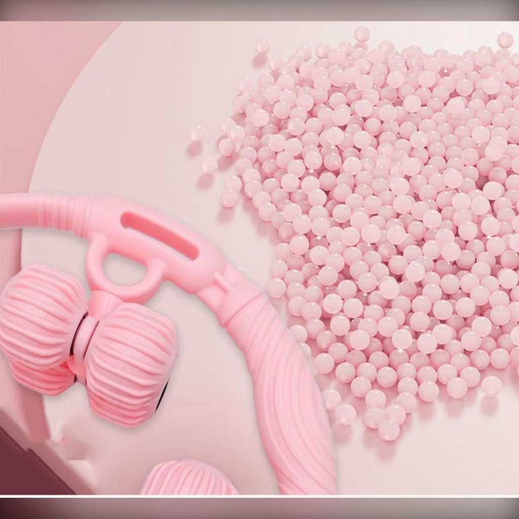 Ein rosafarbener Massagegriff mit zwei Rollen neben einer Ansammlung kleiner rosa Kugeln.